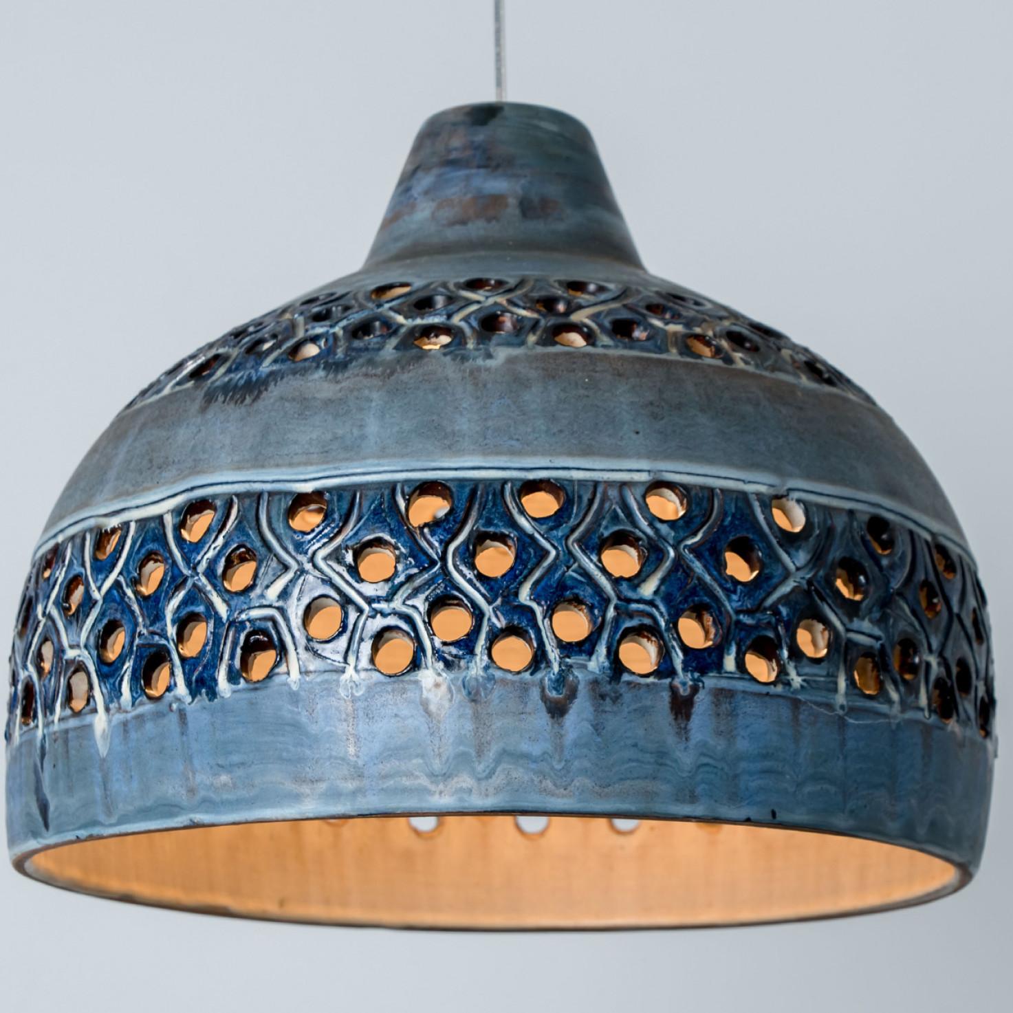 Stunning small round hanging lamp with a bowl-like shape, made with rich blue colored ceramics, manufactured in the 1970s in Denmark. We also have a multitude of unique colored ceramic light sets and arrangements, all available in the front store. 