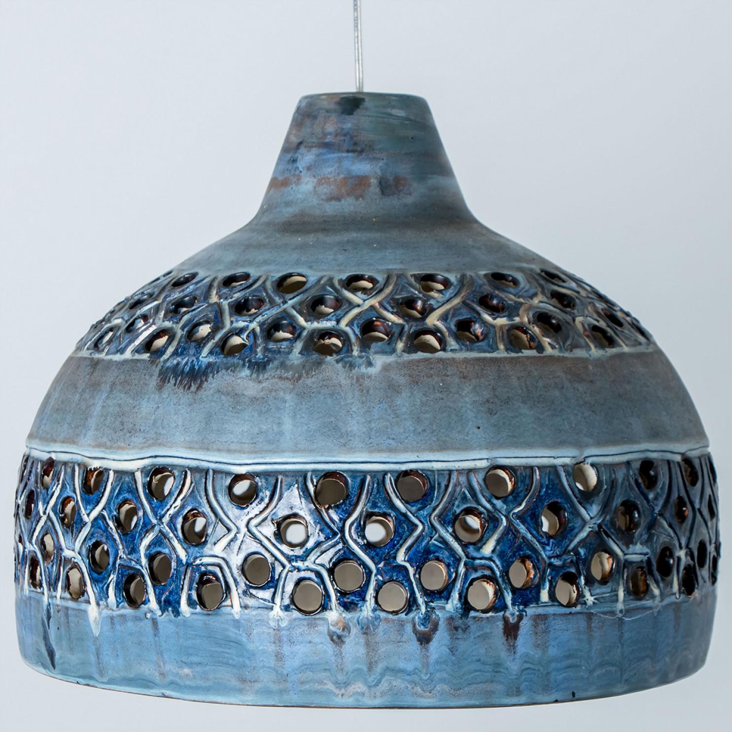 Stunning small round hanging lamp with a bowl-like shape, made with rich blue colored ceramics, manufactured in the 1970s in Denmark. We also have a multitude of unique colored ceramic light sets and arrangements, all available in the front store. 