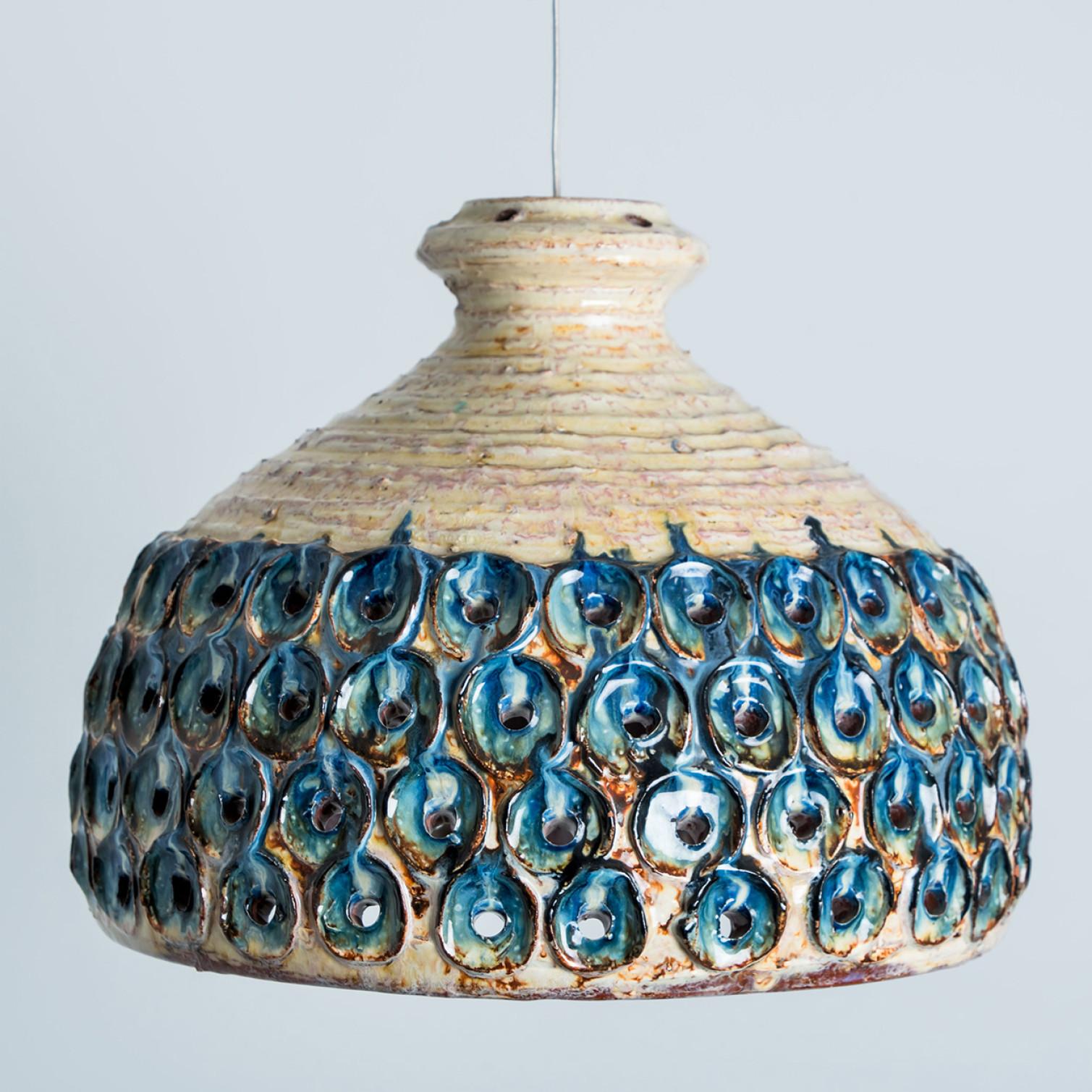 Stunning small round hanging lamp with a bowl-like shape, made with rich blue creme colored ceramics, manufactured in the 1970s in Denmark. We also have a multitude of unique colored ceramic light sets and arrangements, all available in the front