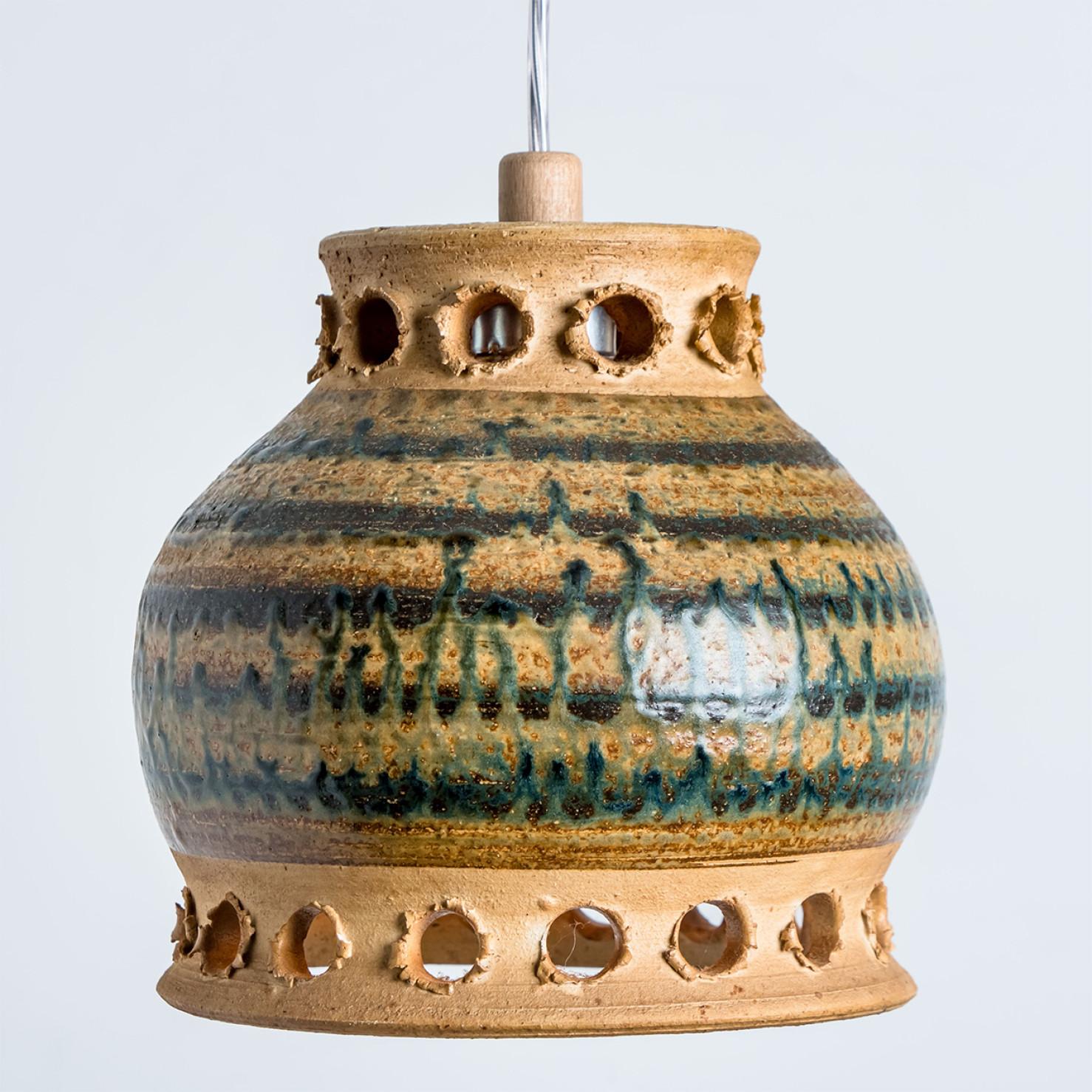 Stunning round hanging lamp with an unusual shape, made with rich brown and green colored ceramics, manufactured in the 1970s in Denmark. We also have a multitude of unique colored ceramic light sets and arrangements, all available on the