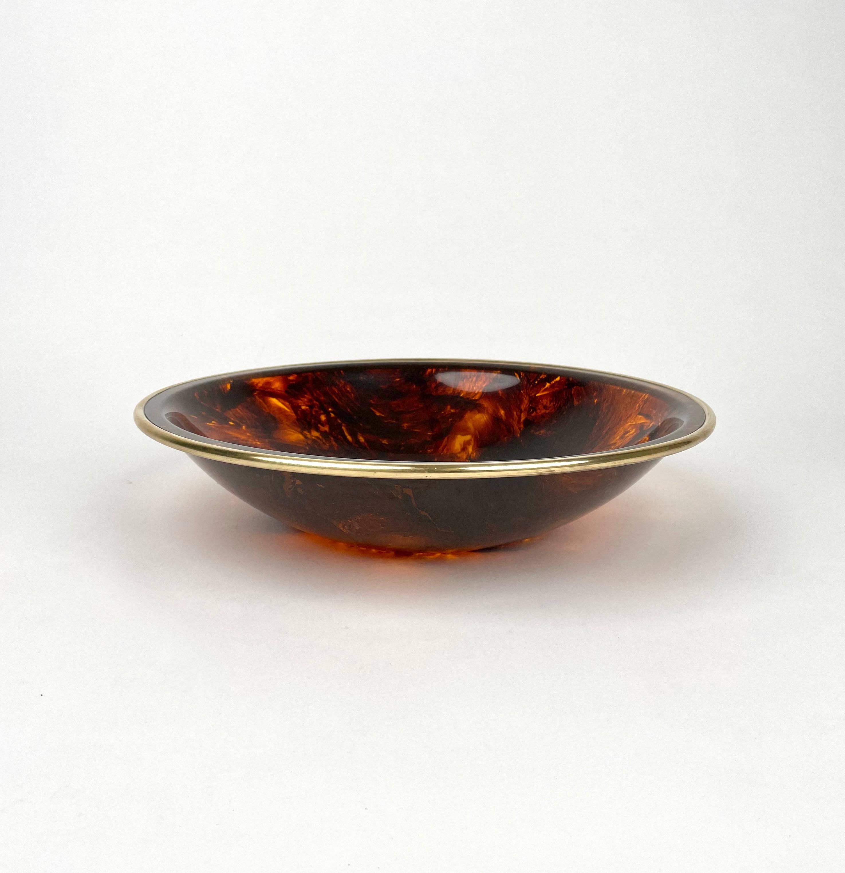 Bowl centerpiece in tortoiseshell-effect lucite with brass border in the style of Christian Dior. 

Made in Italy in the 1970s.