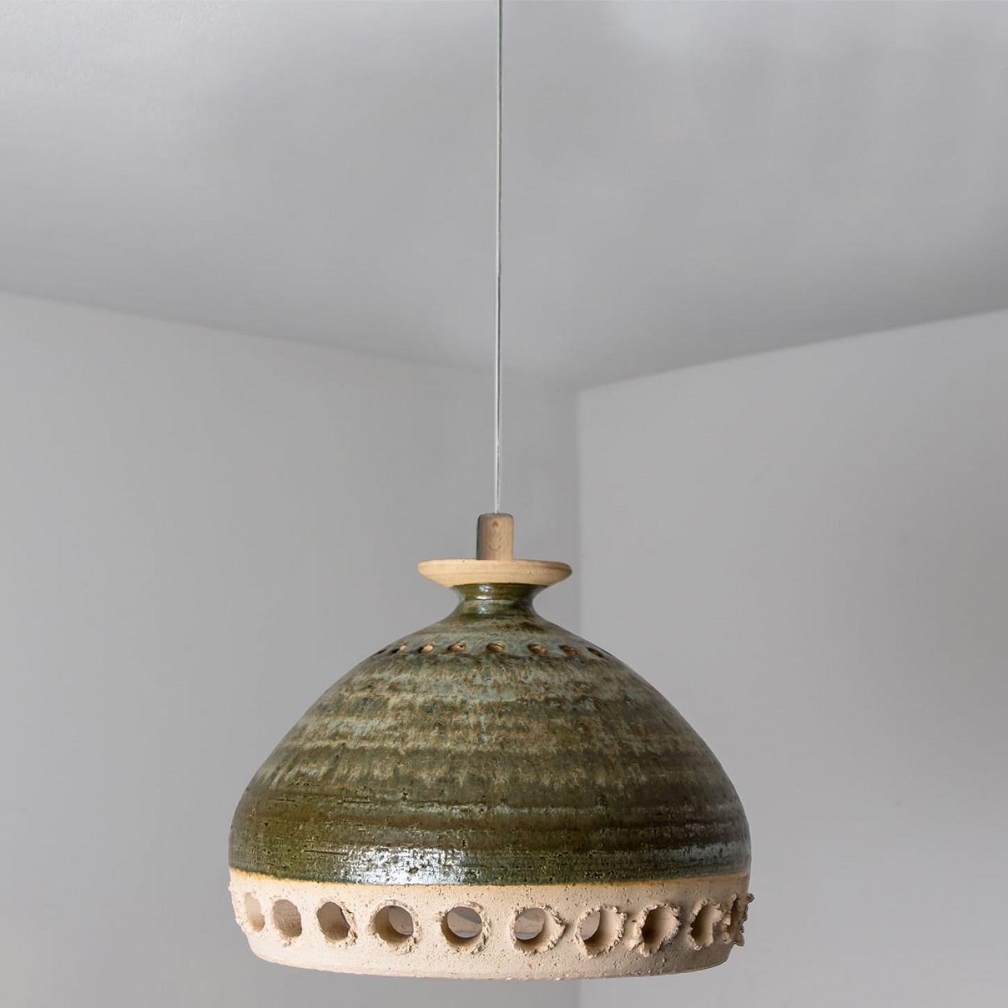 Stunning round hanging lamp with an unusual shape, made with rich green colored ceramics, manufactured in the 1970s in Denmark. We also have a multitude of unique colored ceramic light sets and arrangements, all available on the frontstore.