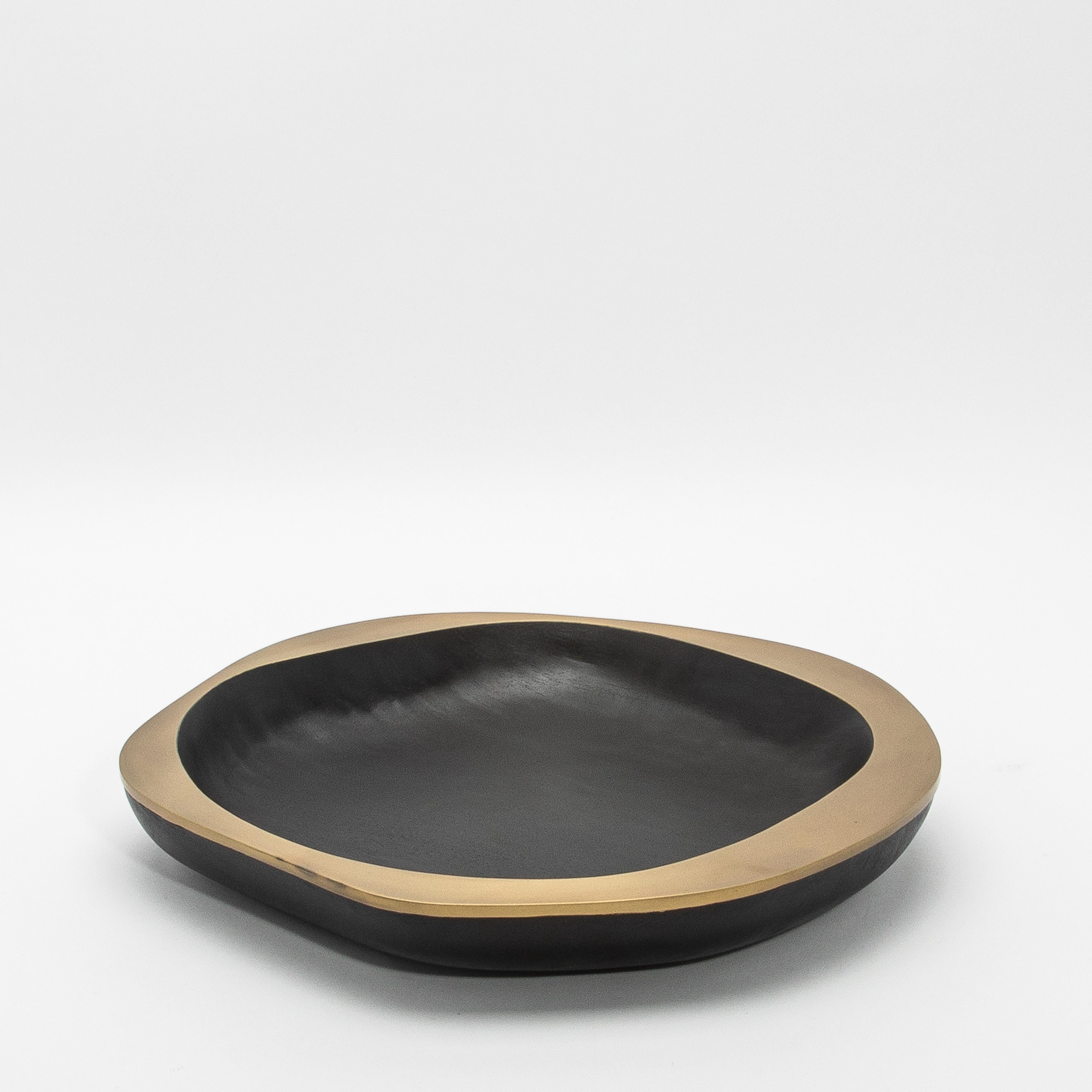 La coupe Lily Bowl en chêne noir avec des détails en laiton patiné par R&Y Augousti est une incarnation étonnante de l'élégance organique et de l'expertise artisanale. Ce chef-d'œuvre sculpté à la main présente une riche base en chêne noir foncé qui