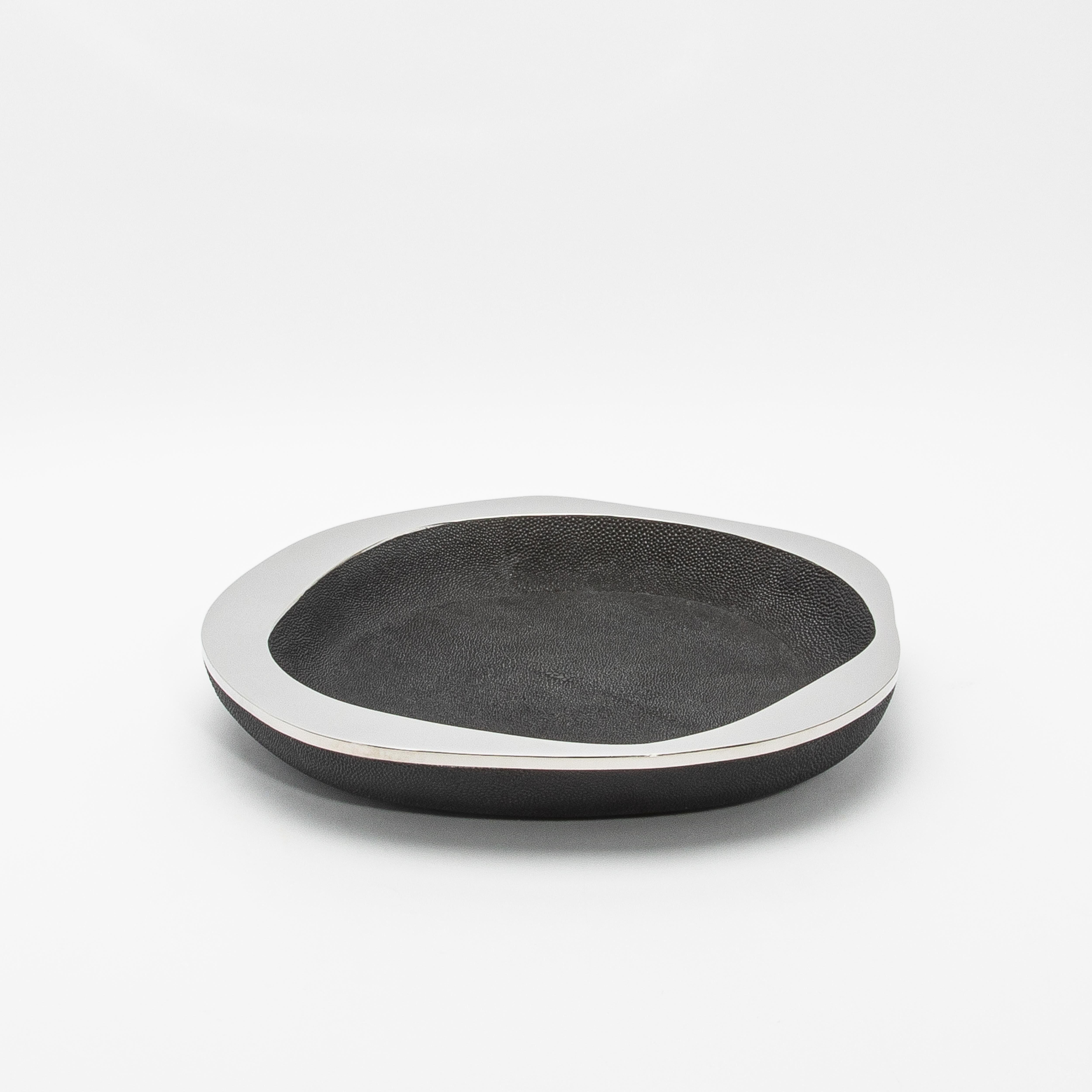 The Lily Bowl in black shagreen with stainless steel details by R&Y Augousti is a masterful blend of elegance and contemporary design. The rich texture of the black shagreen surface is meticulously handcrafted, offering a luxurious, tactile