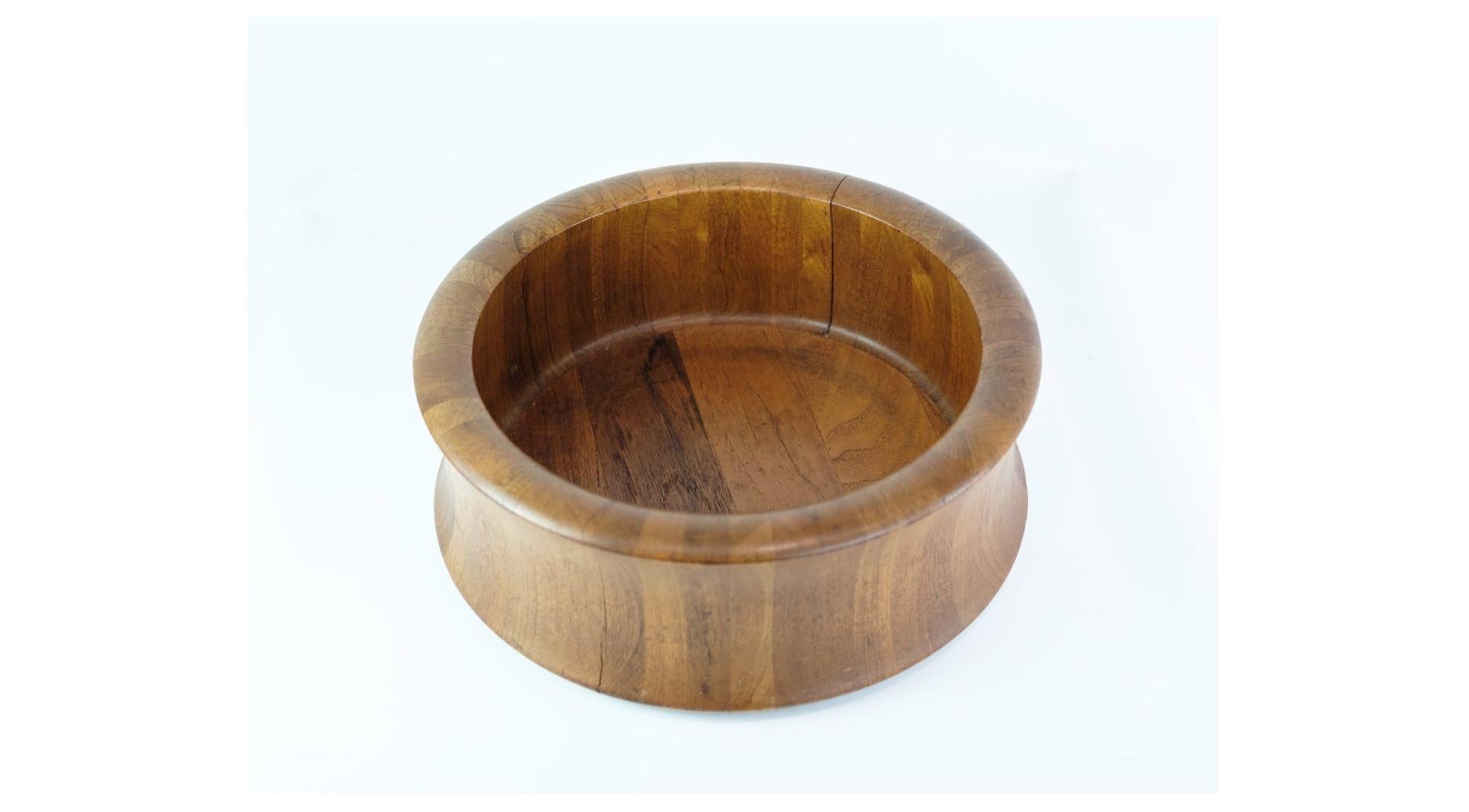 Crafted around the 1960s, this Danish-designed teak wood bowl bears the stamp of Digsmed, embodying the epitome of mid-century Danish craftsmanship and style.

Fashioned from high-quality teak wood, this bowl boasts a rich, warm hue and distinctive