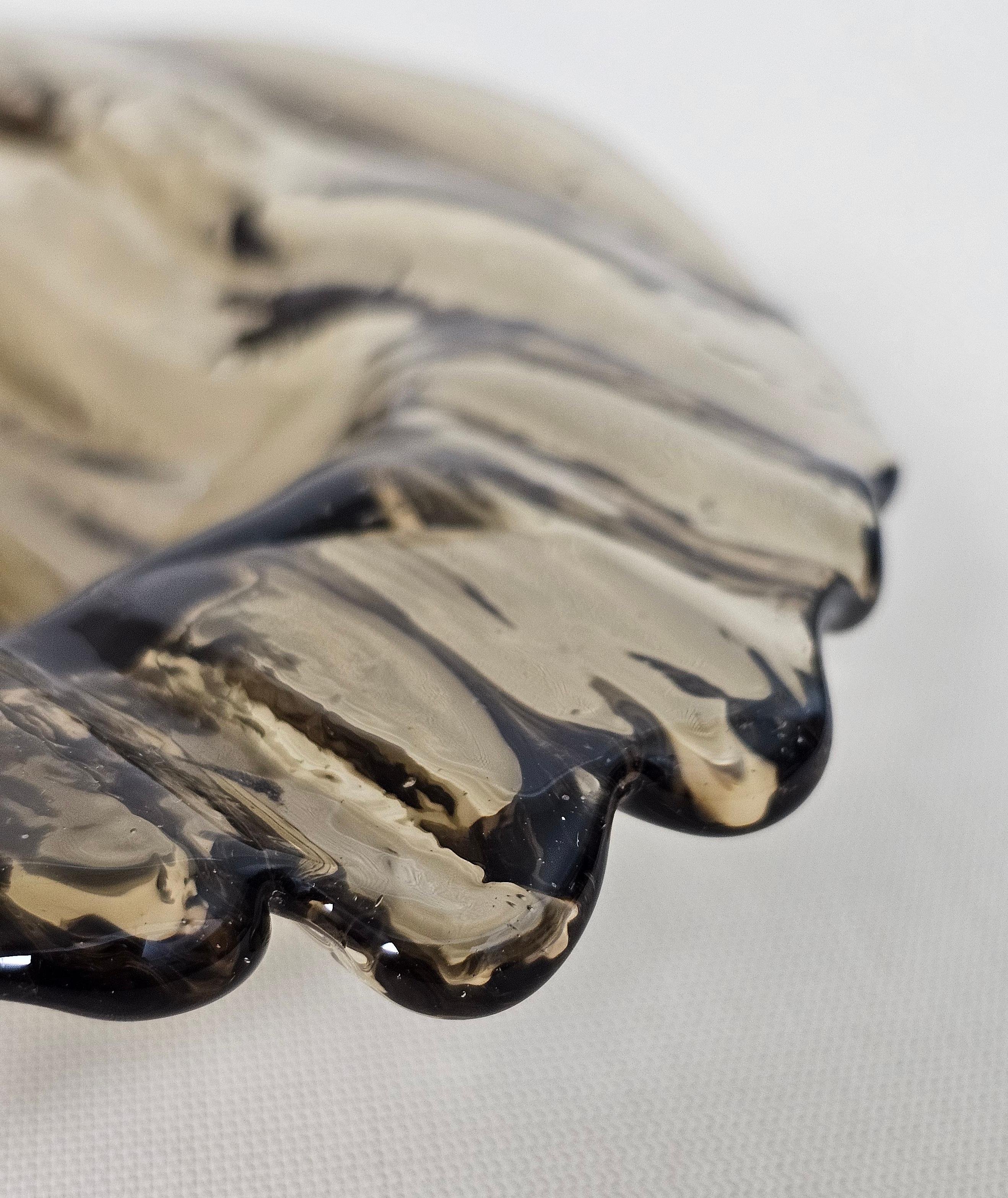 Bowl / pocket emptier in faceted, transparent and amber Murano glass. wavy borders.The vibrant color makes this items highly decorative. This original vintage  element was designed and produced in the 1970s in, Italy. Please watch the video and