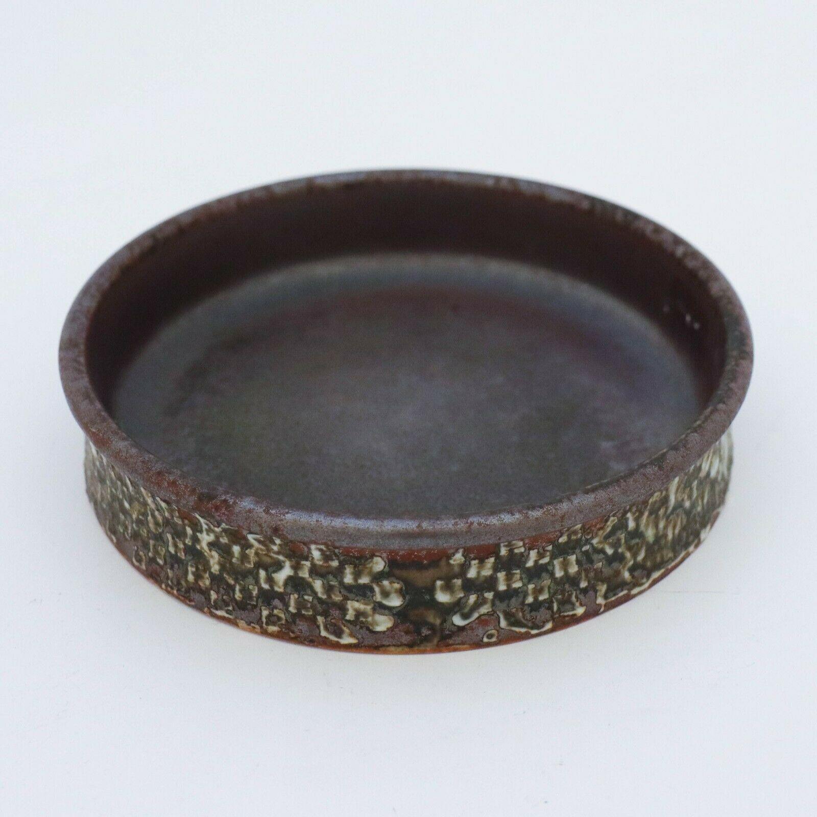 A brown bowl made in stoneware designed by Stig Lindberg at Gustavsbergs Studio. It is 14.5 cm in diameter and 3.2 cm high.