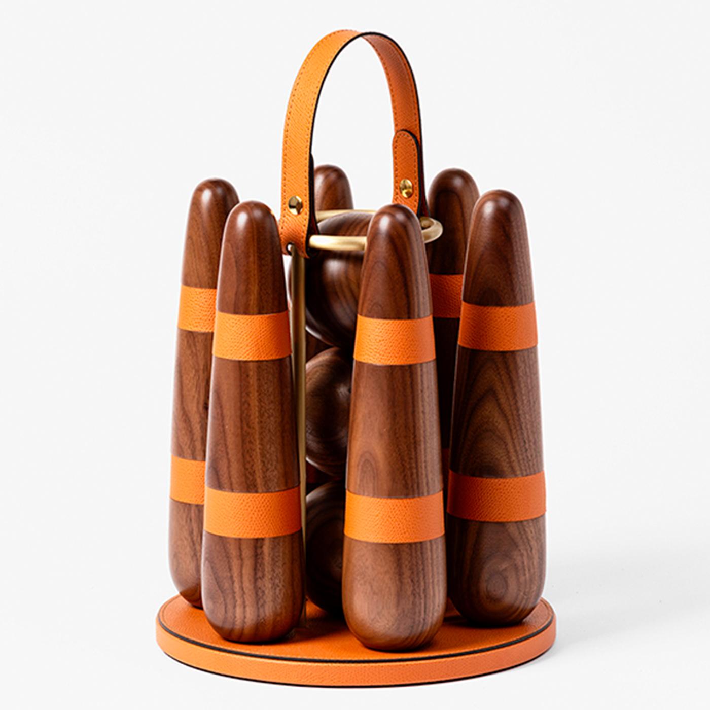 Handcrafted of Canaletto walnut, this portable bowling set includes three balls and six stylized pins with biscuit leather details. A sophisticated gift for any age, the set comes with a stylish holder with a leather handle for easy carrying,