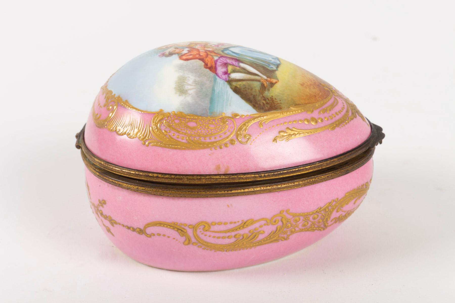 Box, 19th century, Napoleon III period, porcelain and brass mounting, egg, pink, gold decoration and a couple of elegant, interior blans with flower decoration, Sevres brand
Measures: H 8 cm, W 10 cm, P 12 cm.