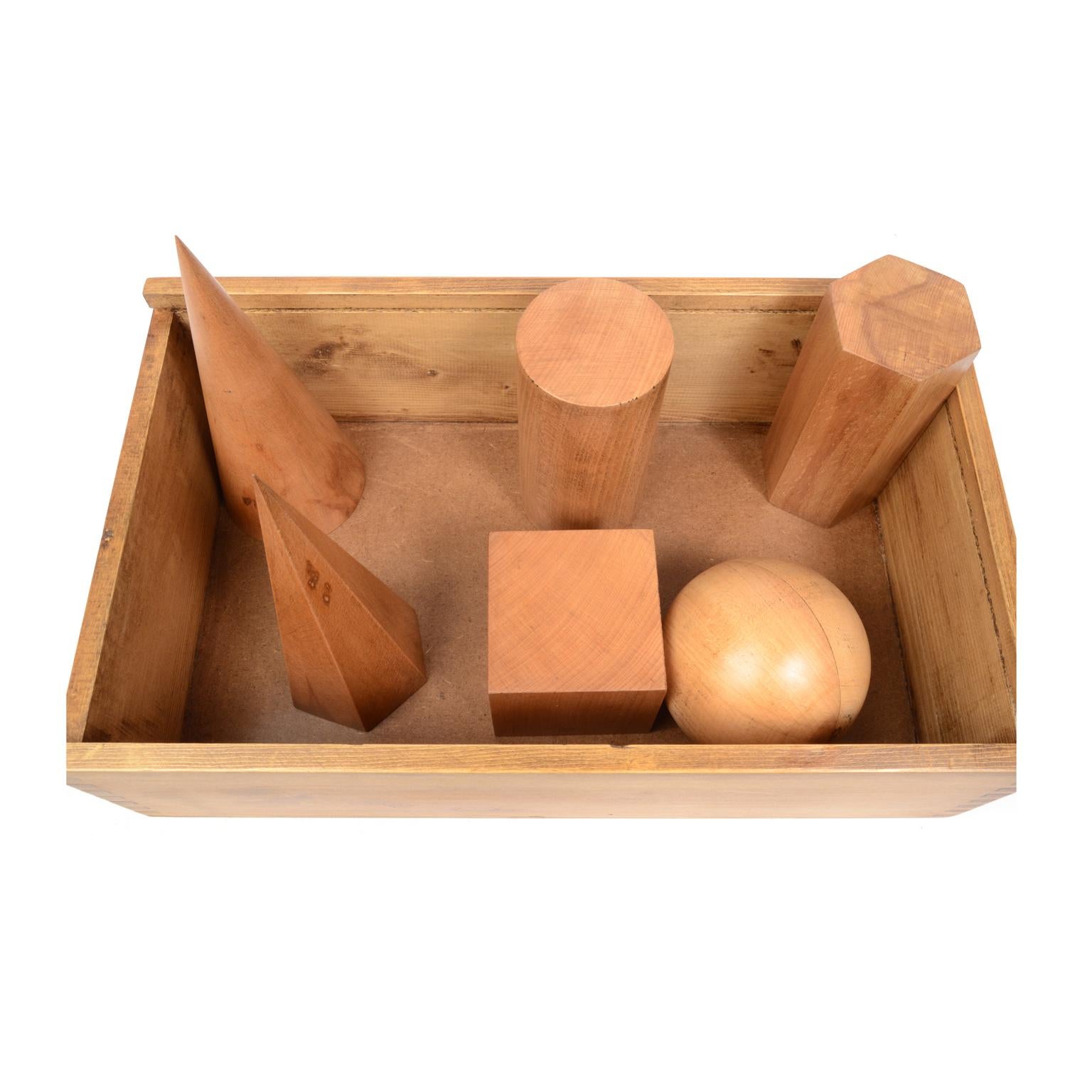 Box containing 6 dismounplate geometric solids of oak wood, height 20 cm, in their original wooden box complete with illustrative leaflet for calculating surfaces and volumes. Made for educational purposes for schools by Antonio Vallardi publisher