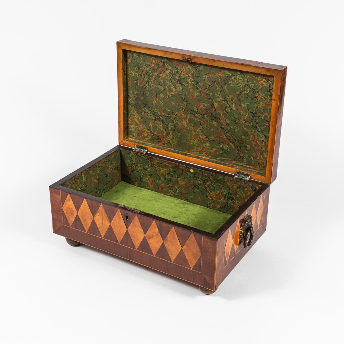 This is a beautifully crafted parquetry box dates back from the regency period in England. The expert craftsmanship is clearly on display in this piece. The exterior of the box is adorned with a parquetry pattern of rows of diamonds, while the