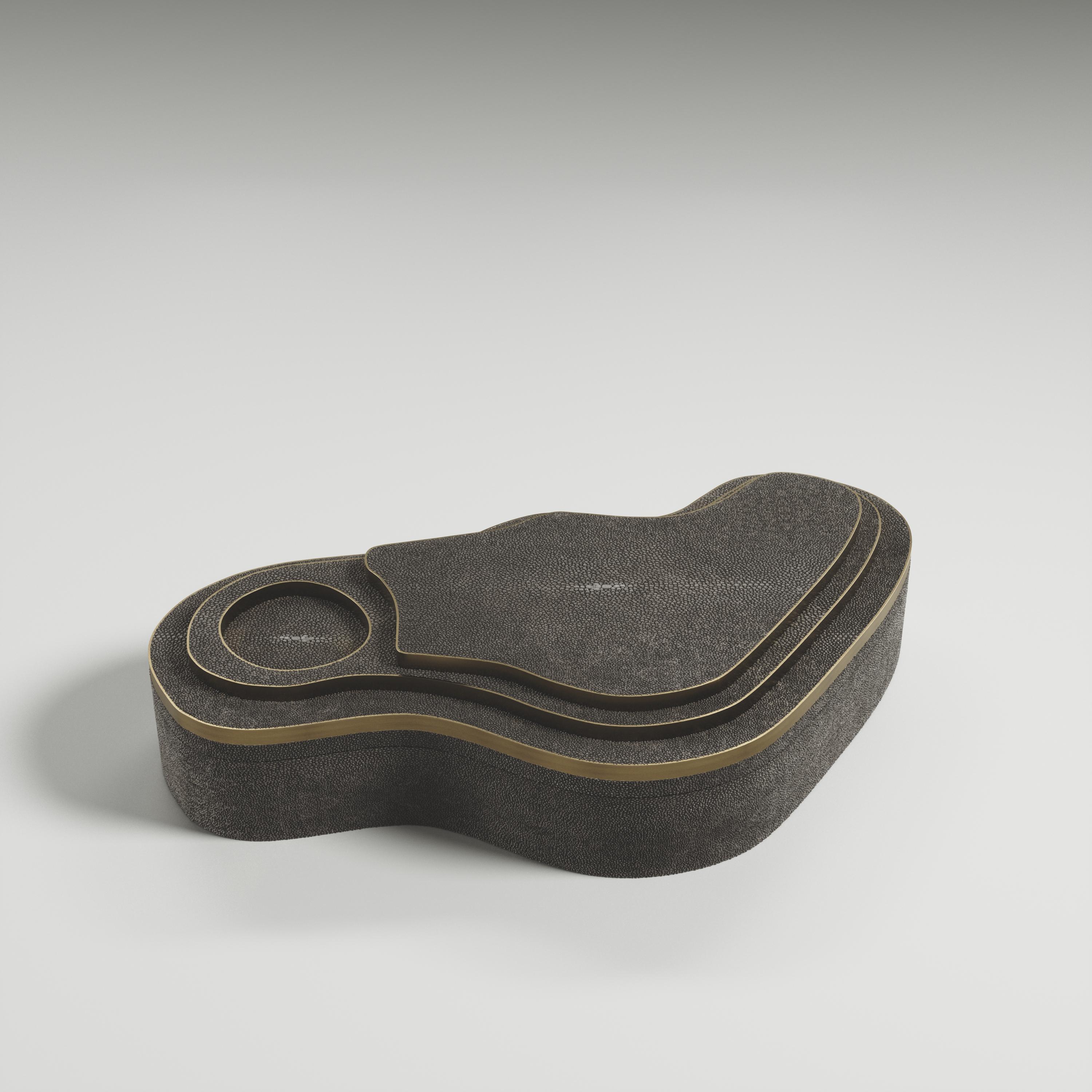 Die Maskenbox mit Relief von Kifu Paris ist ein vielseitiges und organisches Stück. Die amorphe Platte und der Sockel sind mit einer Mischung aus kohleschwarzem Chagrin und Bronze-Patina-Messing eingelegt. Dieses Stück wurde von Kifu Augousti, der