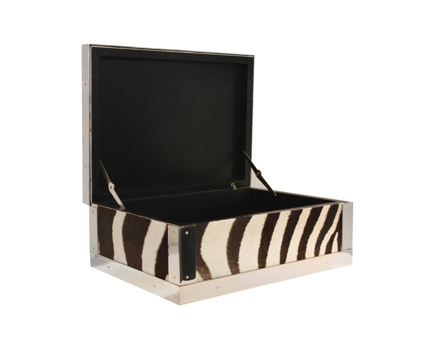 Rectangular wooden box upholstered in genuine zebra leather with metal trims in polished brass nickel plated, mirror finished. One side hinged. 
Genuinely handcrafted in Italy by our artisans.
A statement piece that will enhance every coffee table