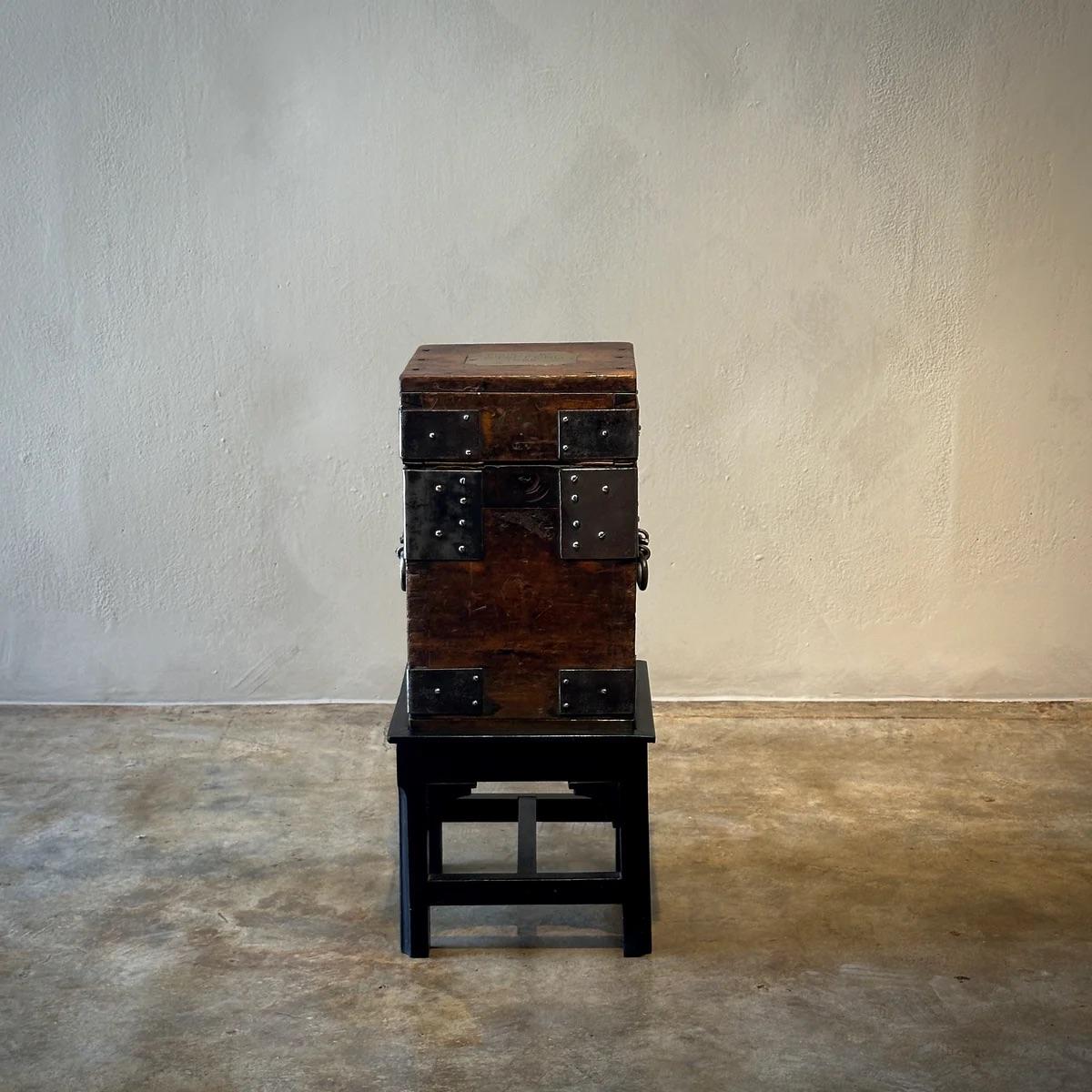 This charming side table is a beautiful representation of 19th-century utility and aesthetics, crafted from richly patinated wood and adorned with robust metal details that lend it a distinctive industrial allure. Its compact form, featuring a stack