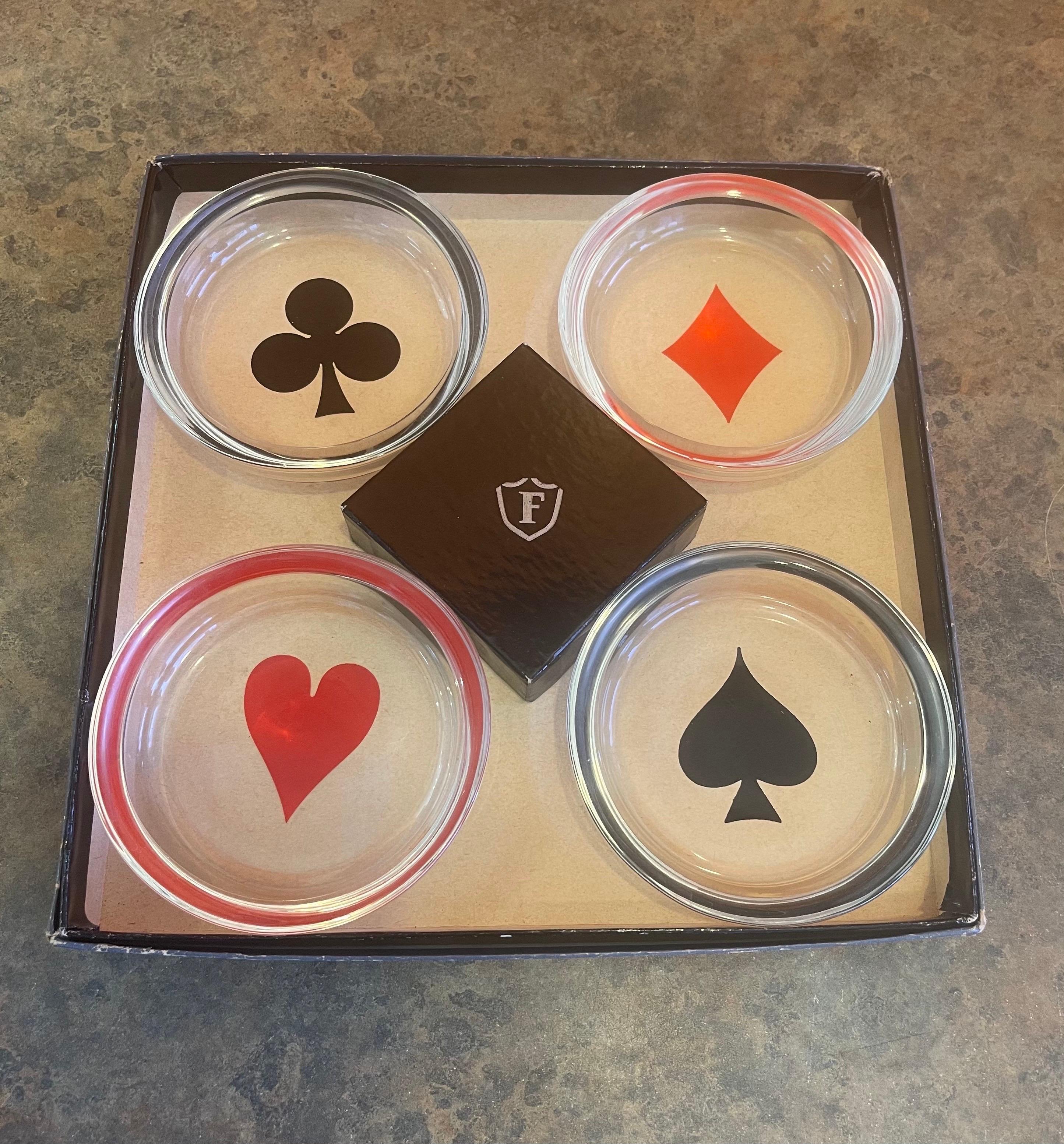 Vintage box set of four MCM poker / card suits themed glass coasters or ashtrays by Federal Glass Co, circa 1960s. The set comes with the original box and includes four round clear coasters that are 3.75