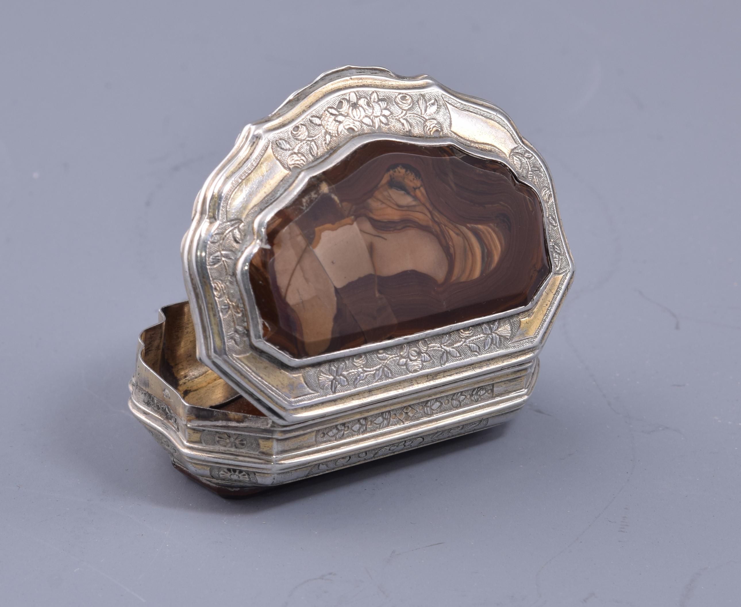 Box. Silver, agate, 19th century.
With contrast marks.
Box made of silver in its color with an elongated shape and wavy profiles decorated with two plates of agate in brown tones and vegetal elements. It maintains in some areas part of the