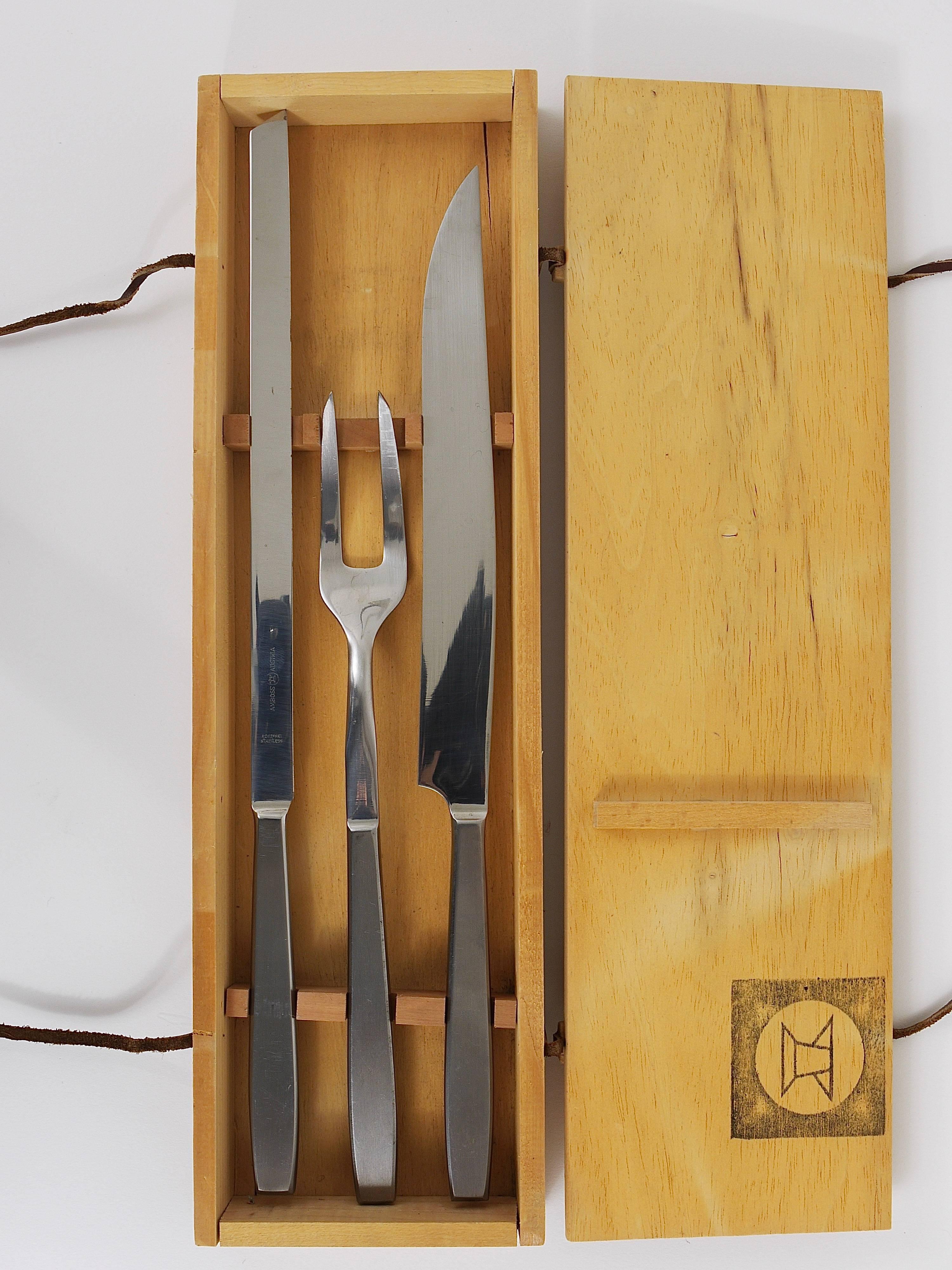 A beautiful midcentury Austrian carving set, consisting of caring knive, a meat knive and a fork in its original award-winning handmade wooden box. Out of the 2050 series, designed by Helmut Alder, executed by Amboss Austria in the 1950s.