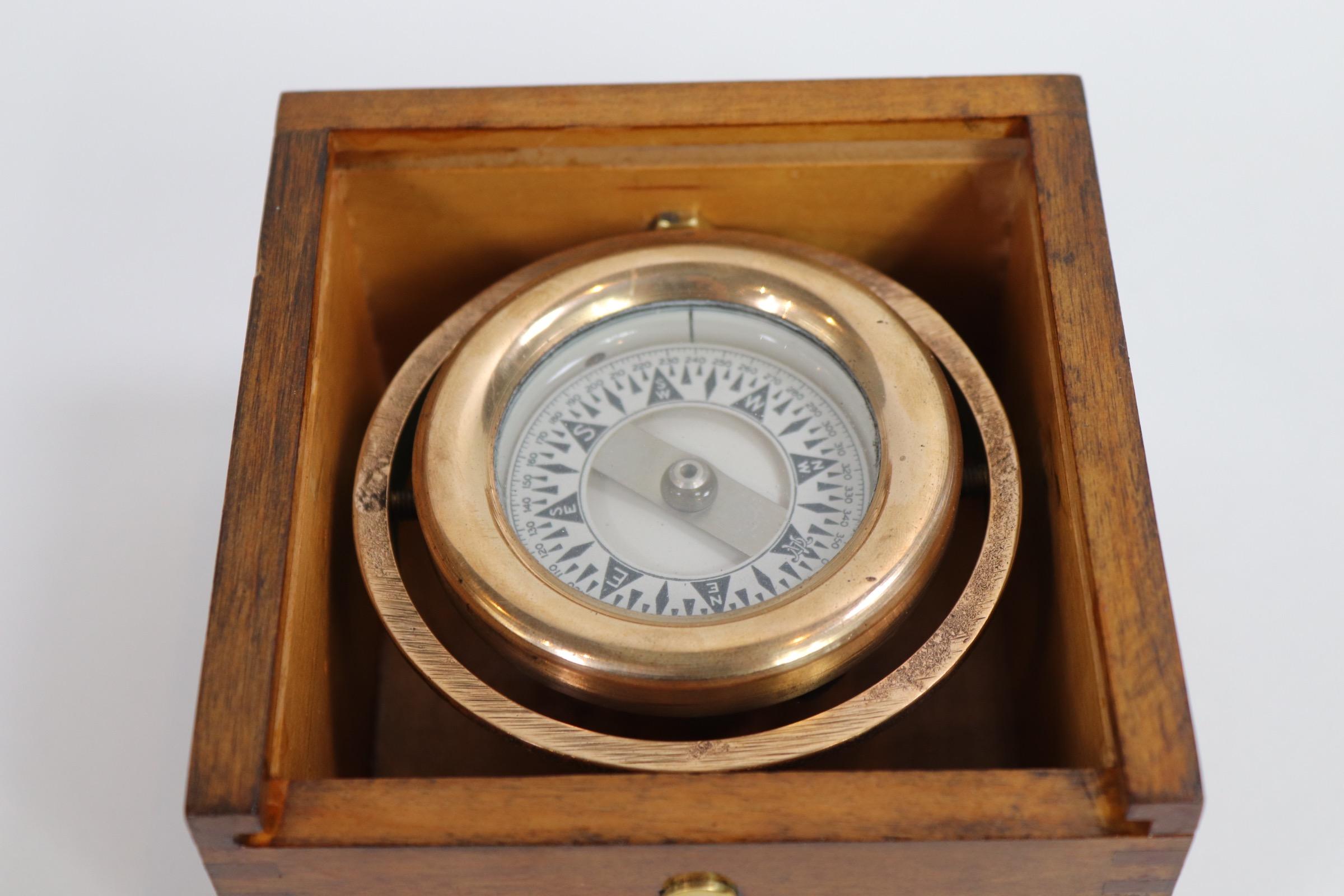 Polished brass boat compass by Connecticut maker Wilcox Crittenden. Fitted to a dovetailed box. Lacking its sliding cover. Weight is 2 pounds.