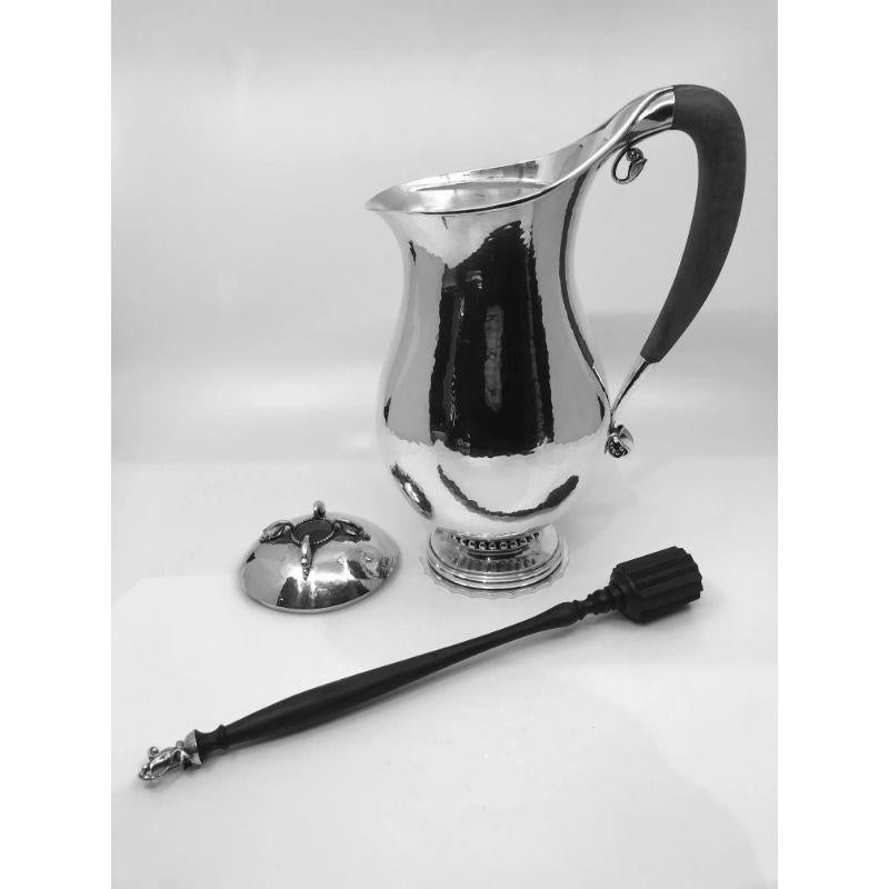 Georg Jensen sterling silver chocolate pot with a mahogany handle and a silver mounted rosewood stirrer, design #460B by Georg Jensen from 1925.

Additional information:
Material: Sterling silver
Styles: Art Nouveau
Hallmarks: Marked with Georg