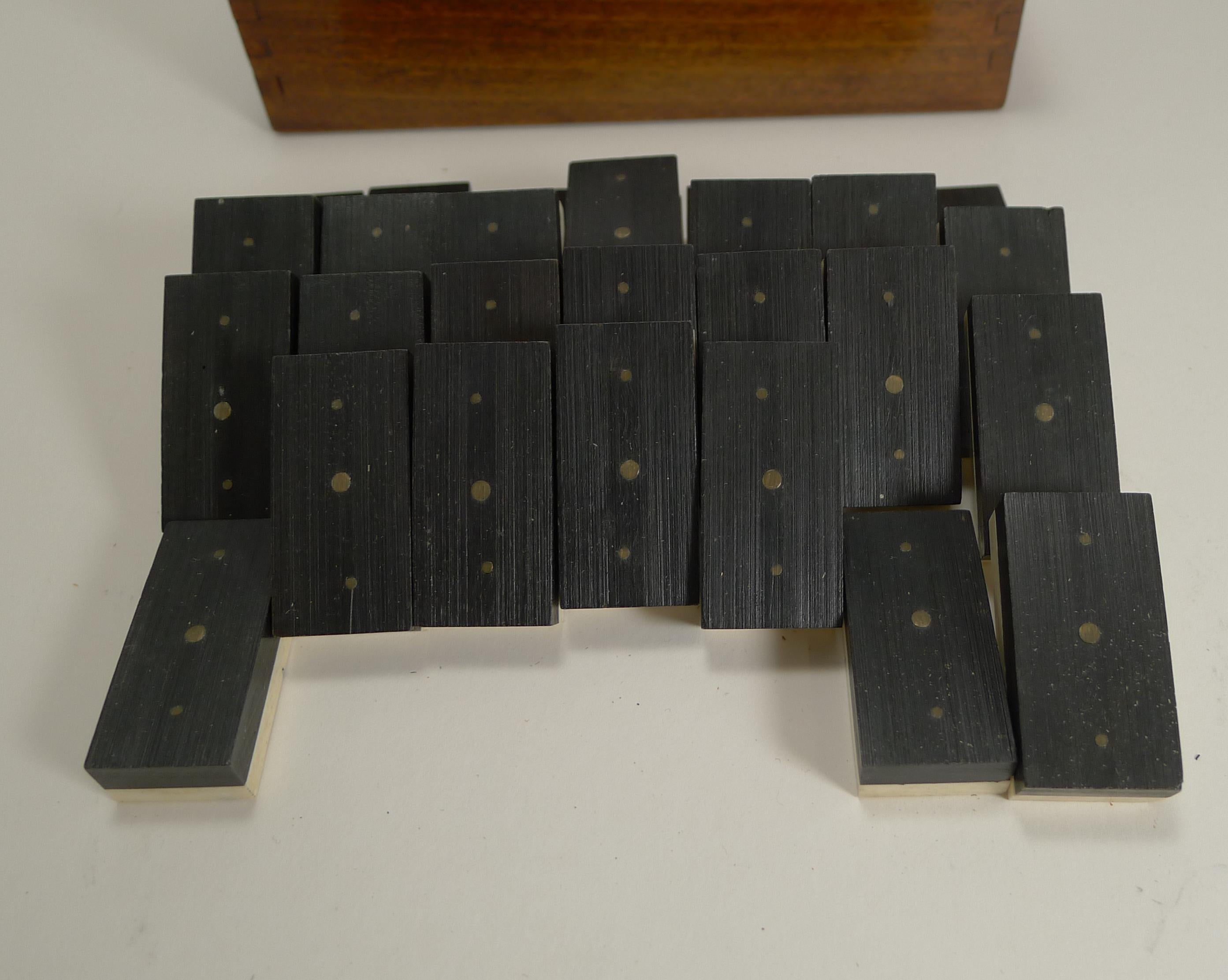 A charming set of late Edwardian dominoes or dominos, all in good condition with a handsome polished wooden storage box with a sliding lid.

The bone and Ebony pinned together with small brass pins. The inside is stamped with the makers