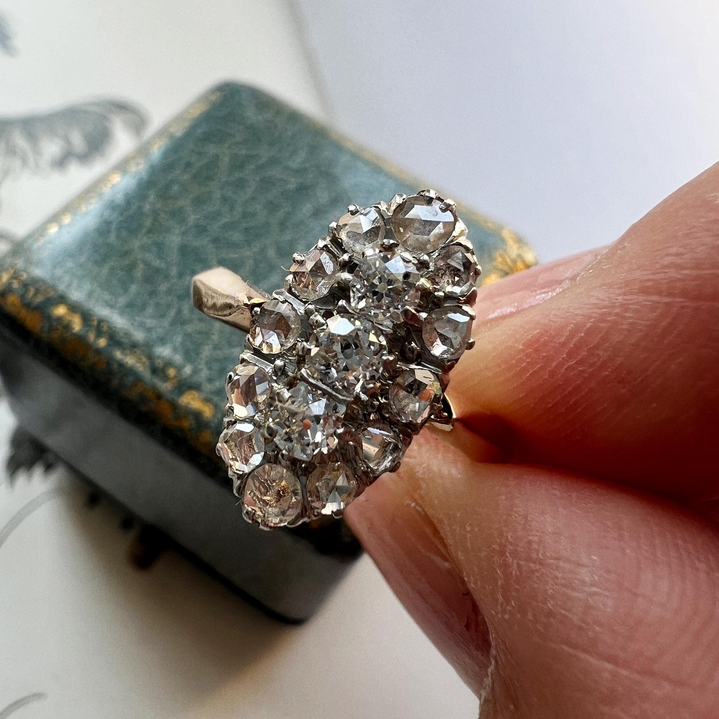 For sale an antique ring from the Victorian era. The ring features a marquise ring head that is fully pave set with sparkling diamonds. The central three diamonds are old mine cut, weighing approximately 0.3ct in total, and they are surrounded by 12