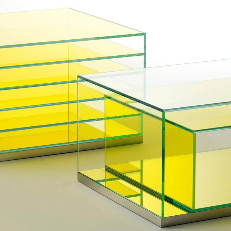 A series of low tables and closed and open storage furniture, designed like a box within a box, in laminated 5+5 mm thermo-welded extra light glass. These are placed on a base of reflective polished stainless steel. A space within the transparent