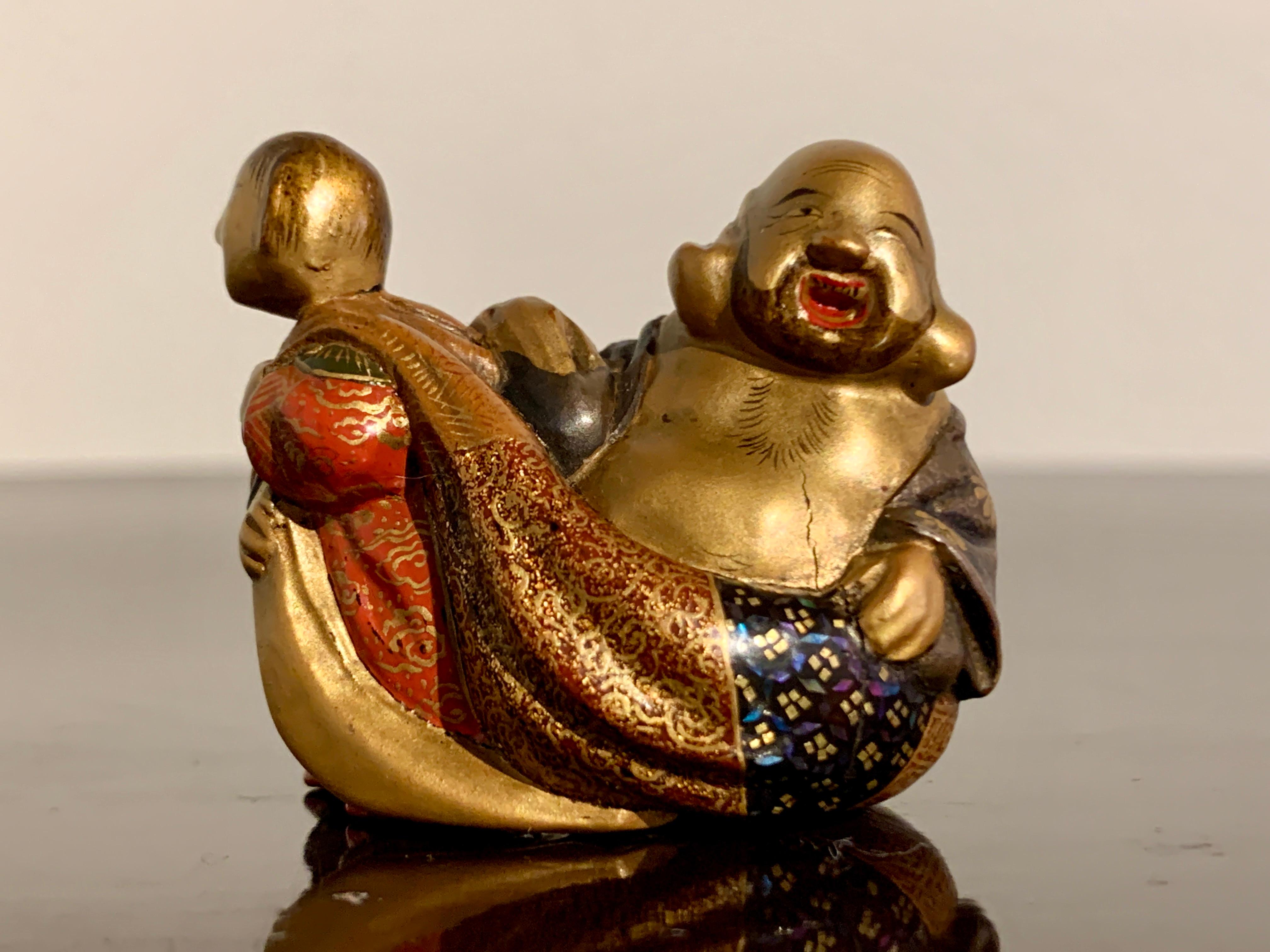 A charming and finely decorated carved and lacquered boxwood netsuke of Hotei by Shunsho (probably Shunsho XI, Masaoki), Meiji period, circa 1900, Japan.

This delightful and colorful netsuke features the beloved figure Hotei, one of the Seven
