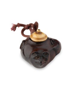 Boxwood nestuke in the form of a kettle transforming into a raccoon dog