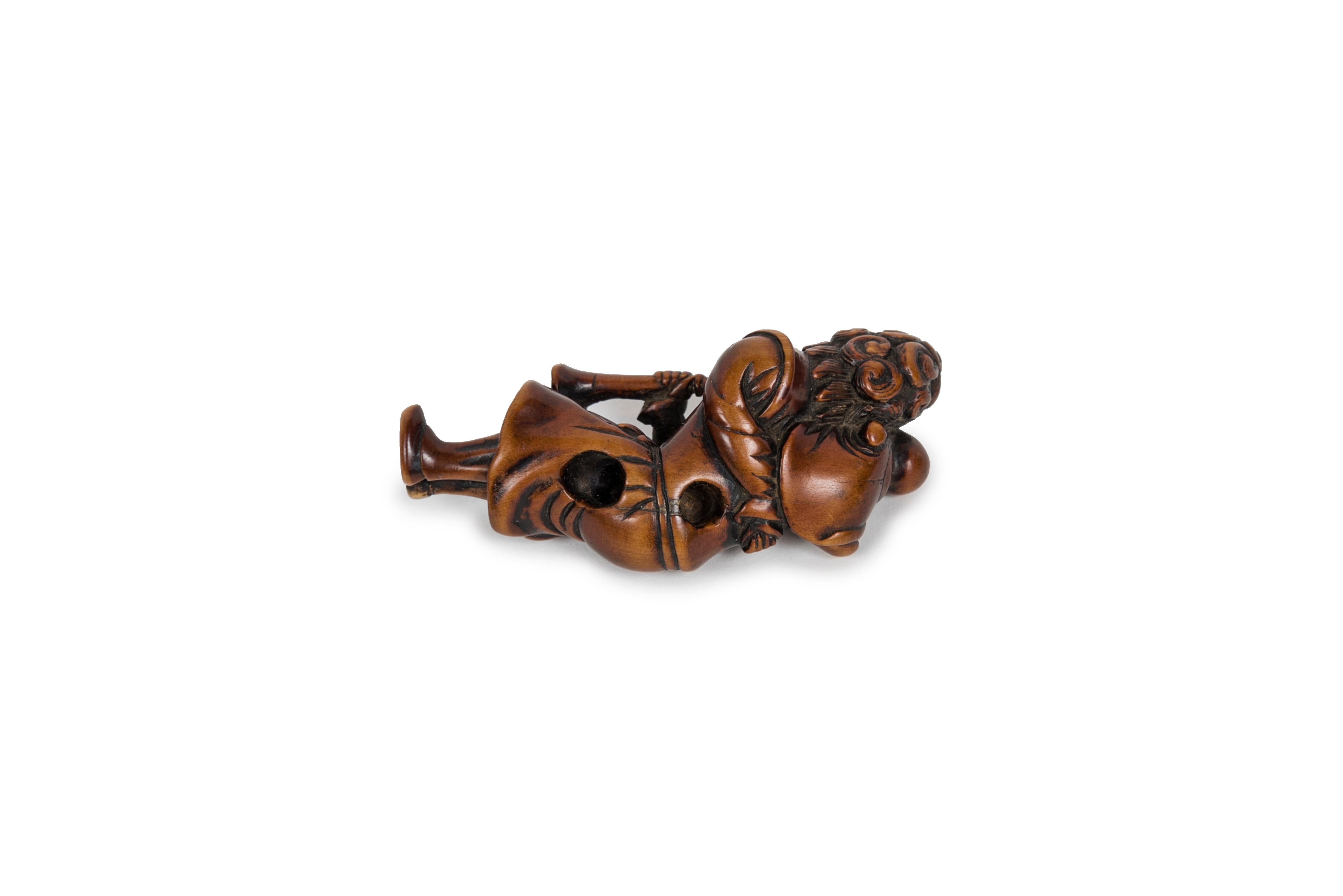 Japanese Boxwood netsuke representing a ducthman with child and a trumpet For Sale