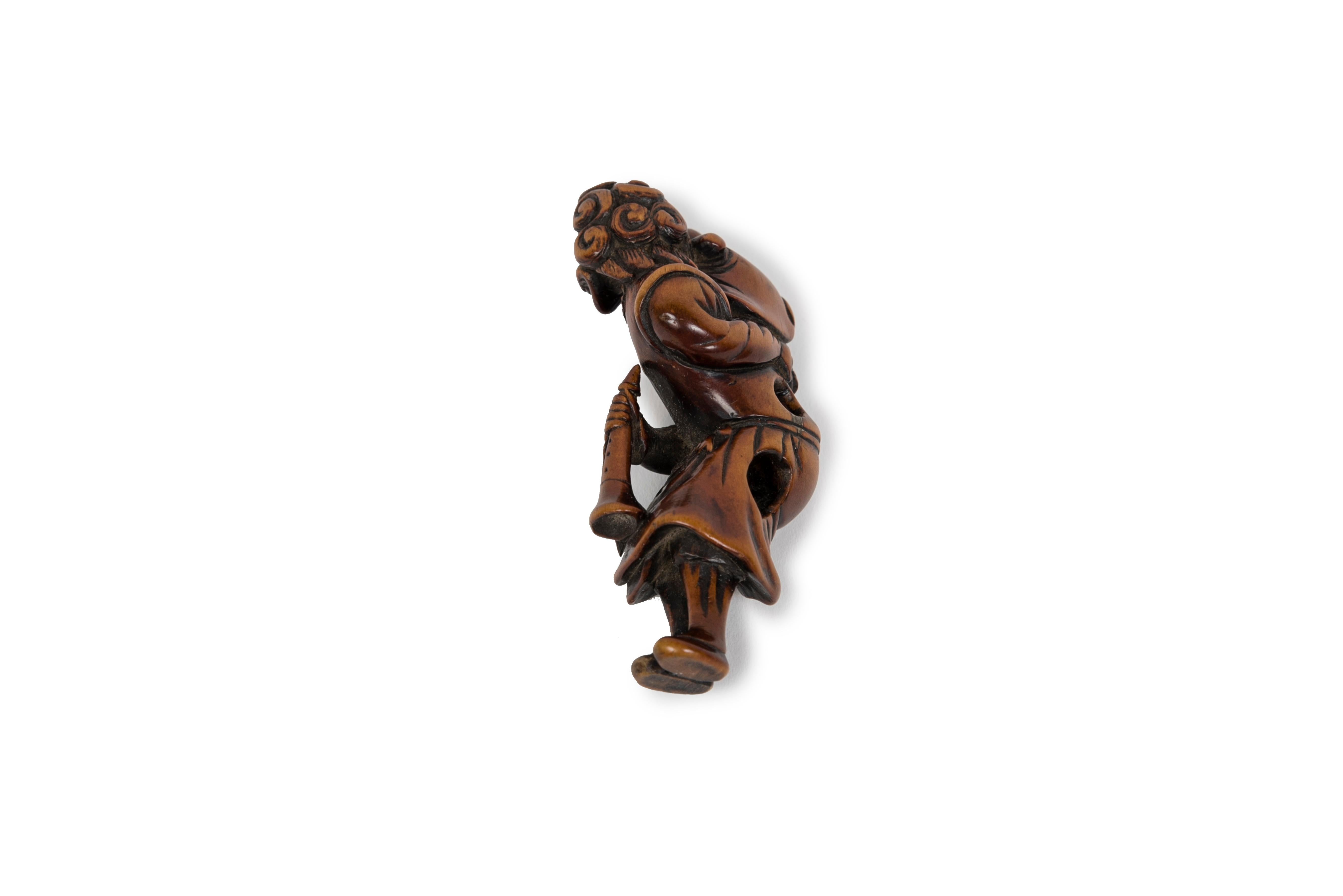 Carved Boxwood netsuke representing a ducthman with child and a trumpet For Sale