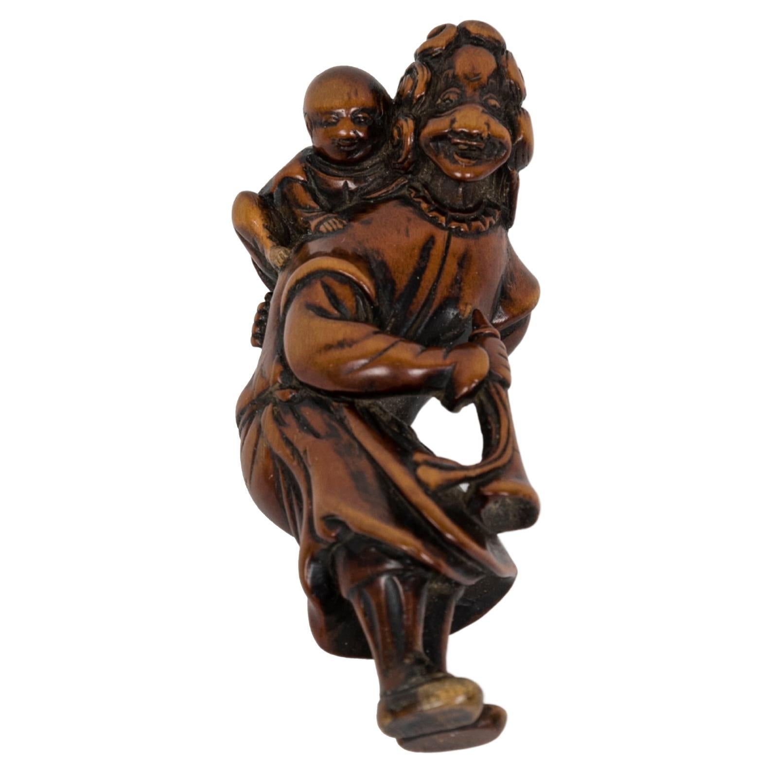 Boxwood netsuke representing a ducthman with child and a trumpet