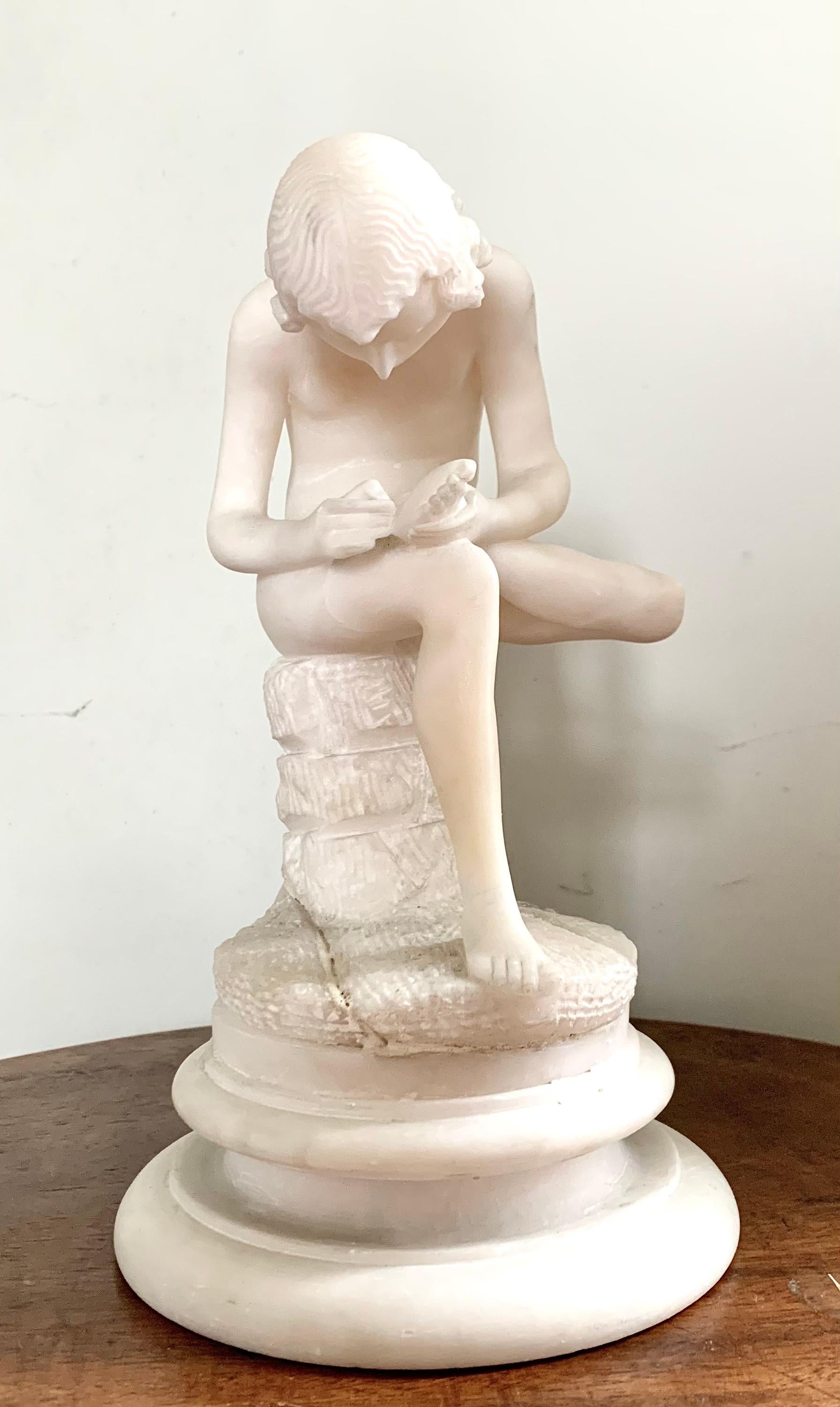 Jolie sculpture en albâtre d'un jeune homme enlevant une épine de son pied.
Thème maintes fois repris dans la sculpture, le plus ancien exemple connu du garçon à l'épine, ou Spinaro, date du 1er siècle avant J.-C. selon les modèles des statues