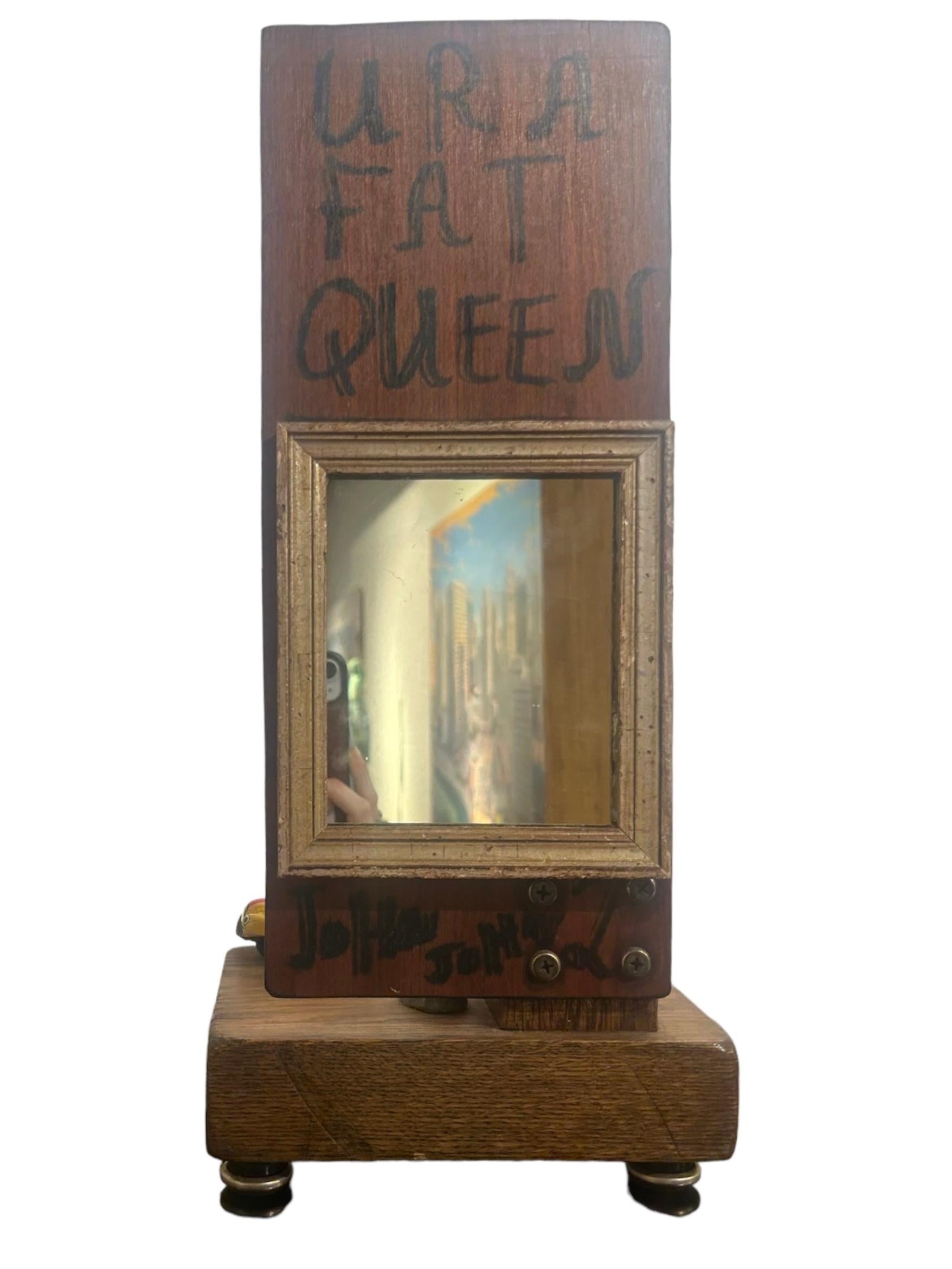 Self-taught artist John Seubert, AKA John Dolly, repurposes objects he uncovers as he rehabs older homes in Chicago. Here, a framed mirror is attached to the back of a multi object construction with  small figural painting. The pieces are attached