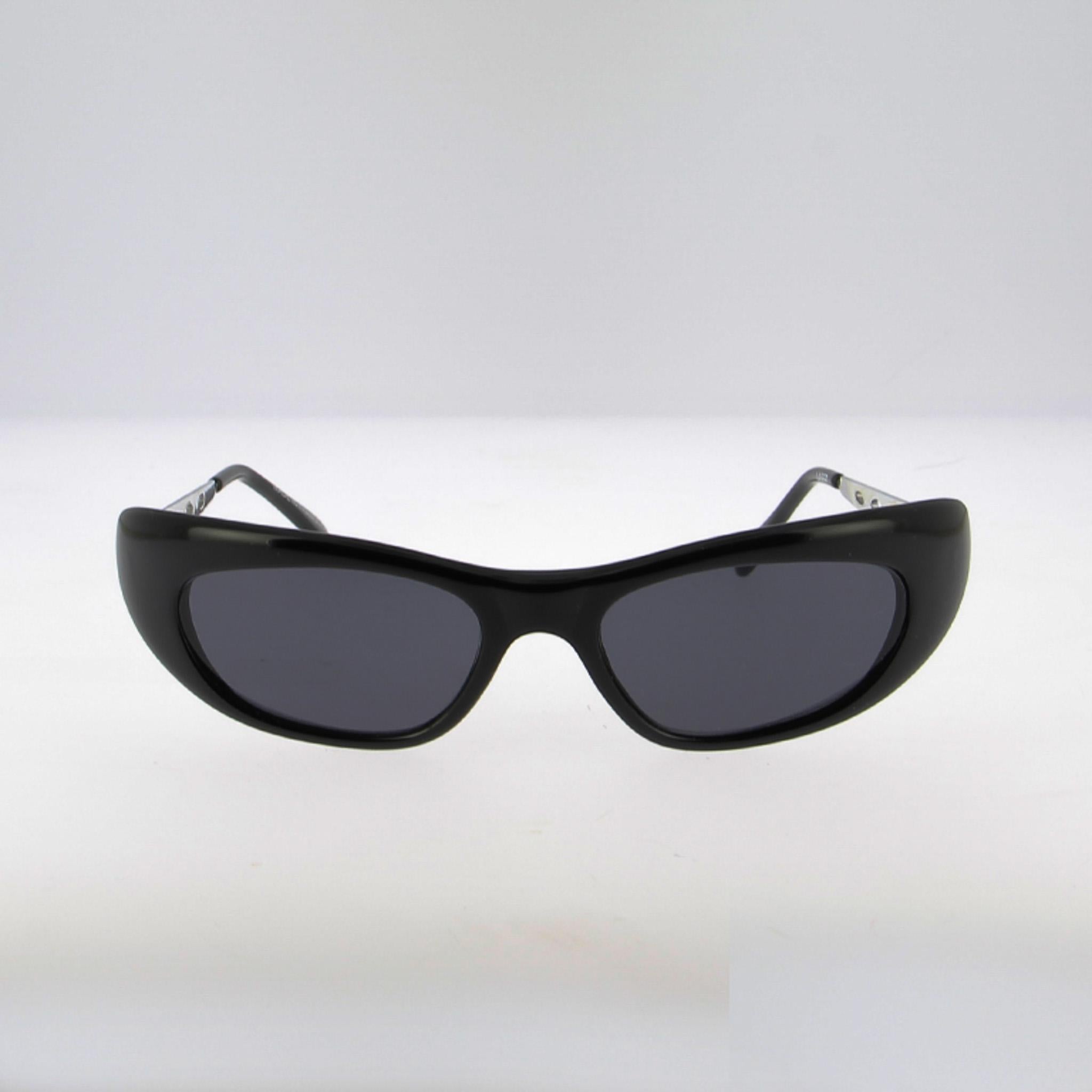 Elegante ojo de gato alargado con una actitud sporty-chic: frontal de acetato negro brillante con puente de silla esculpido y almohadillas integradas para un ajuste firme y cómodo. La poca altura de la lente crea un aspecto rápido y aerodinámico, al