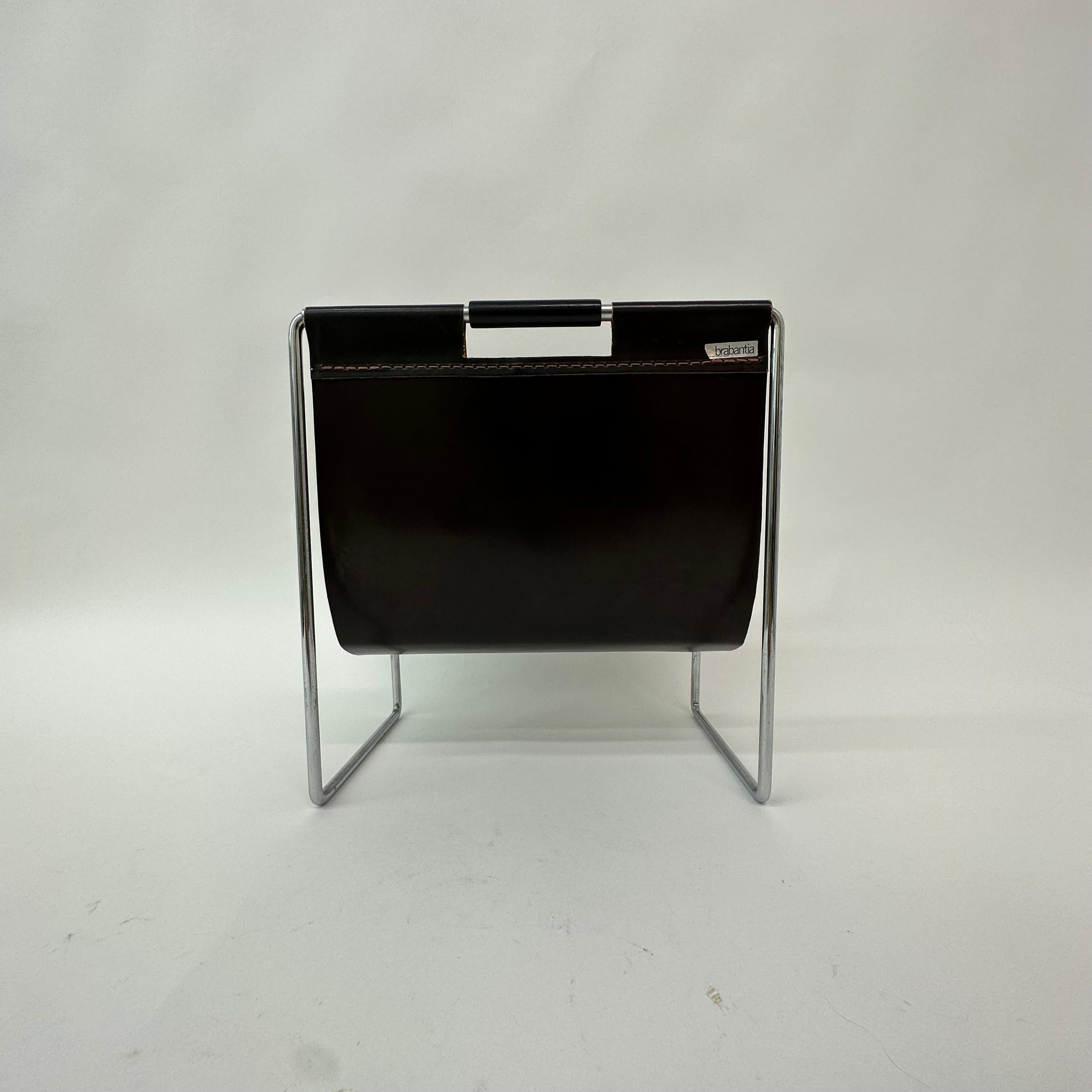 In vintage condition, a beautiful industrial Canterbury / magazine rack made of leather, two wooden handles and with a chrome metal frame, produced by the Brabantia Holland manufacturer and Dadime, which was a furniture brand of Brabantia. Please