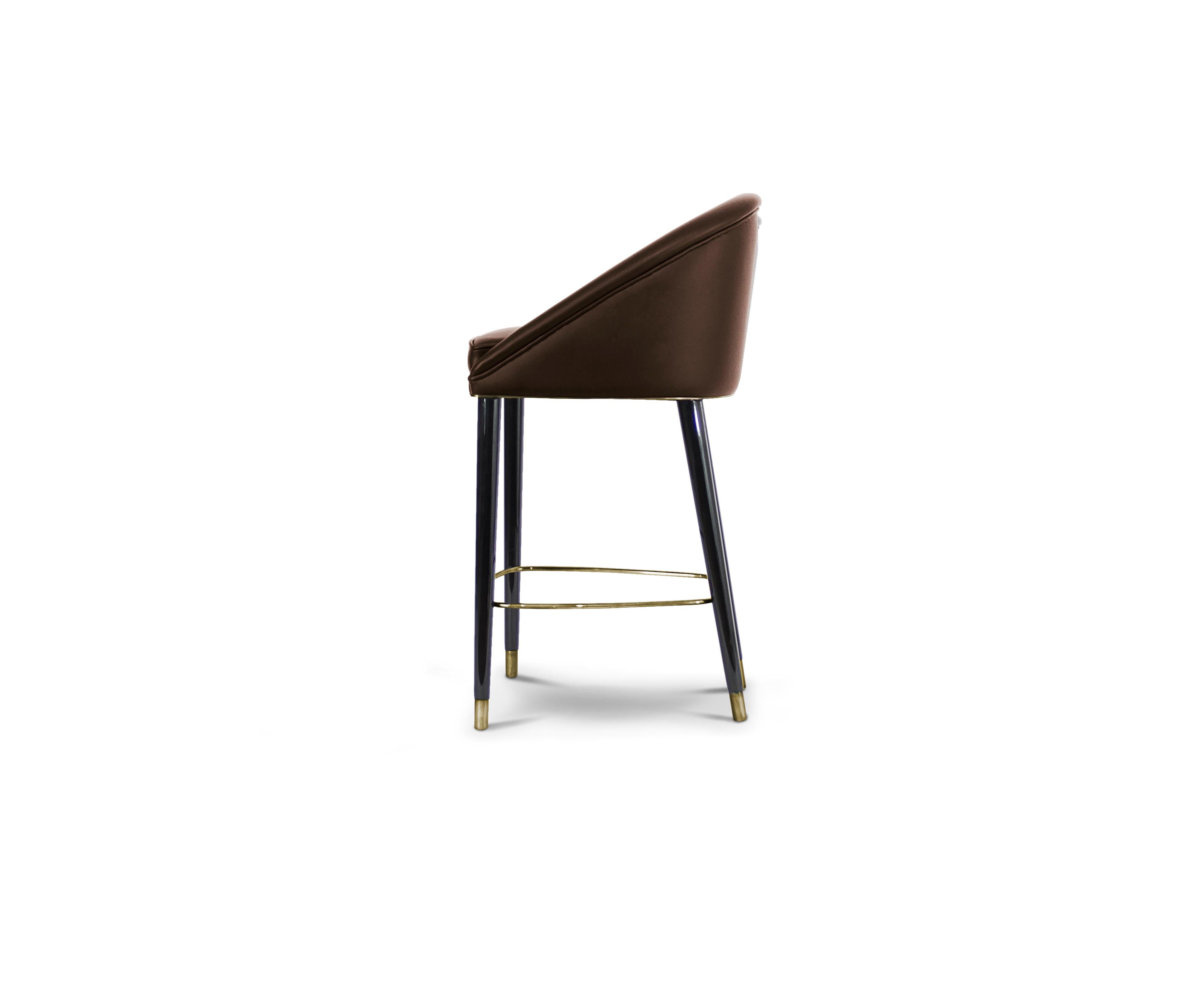 The ethnicities of the mesmerizing Malay Archipelago inspired the creation of MALAY Leather Counter Stool, a twist on mid-century modern furniture. This tufted upholstered chair in synthetic leather and glossy black lacquered legs with aged brass