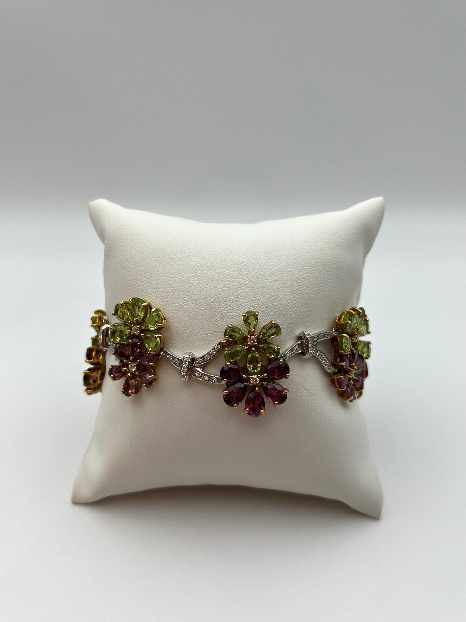 Raffinato bracciale realizzato artigianalmente in Italia in oro bianco e giallo 18 kt. 750/00. La composizione floreale è ondulata , un dettaglio che impreziosisce e caratterizza. Ogni fiore è composto da un'alternanza di peridot e rodolite tagliate