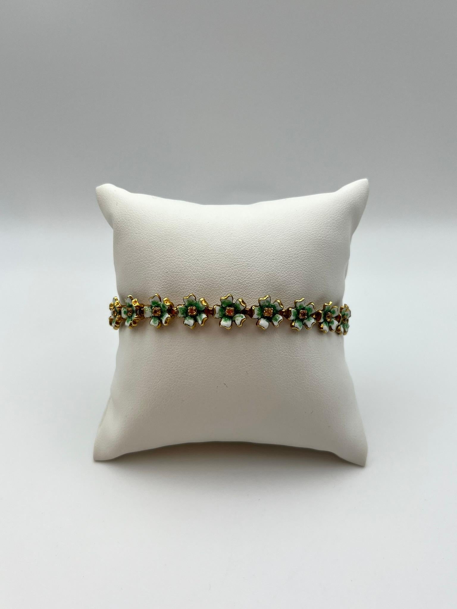 Bracelet artisanal caractérisé par une séquence continue de petits éléments floraux en or jaune 750/00 18 kt, chacun rehaussé d'émaux d'un vert profond. La fabrication présente des détails minutieux et une construction structurée qui confère au