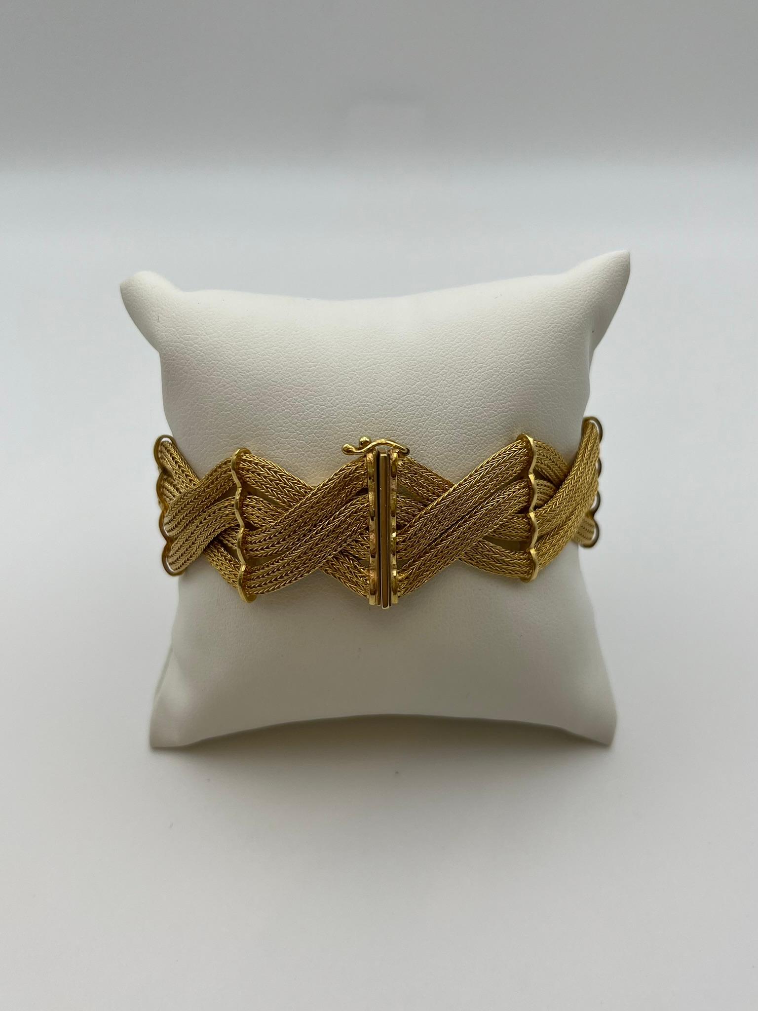 Elégant bracelet réalisé à la main en or jaune 18 carats, caractérisé par un entrelacs raffiné formant un motif continu et ondulant. Le fermoir est doté d'un crochet en forme de 8 pour garantir la sécurité. Le design est sophistiqué, typique des
