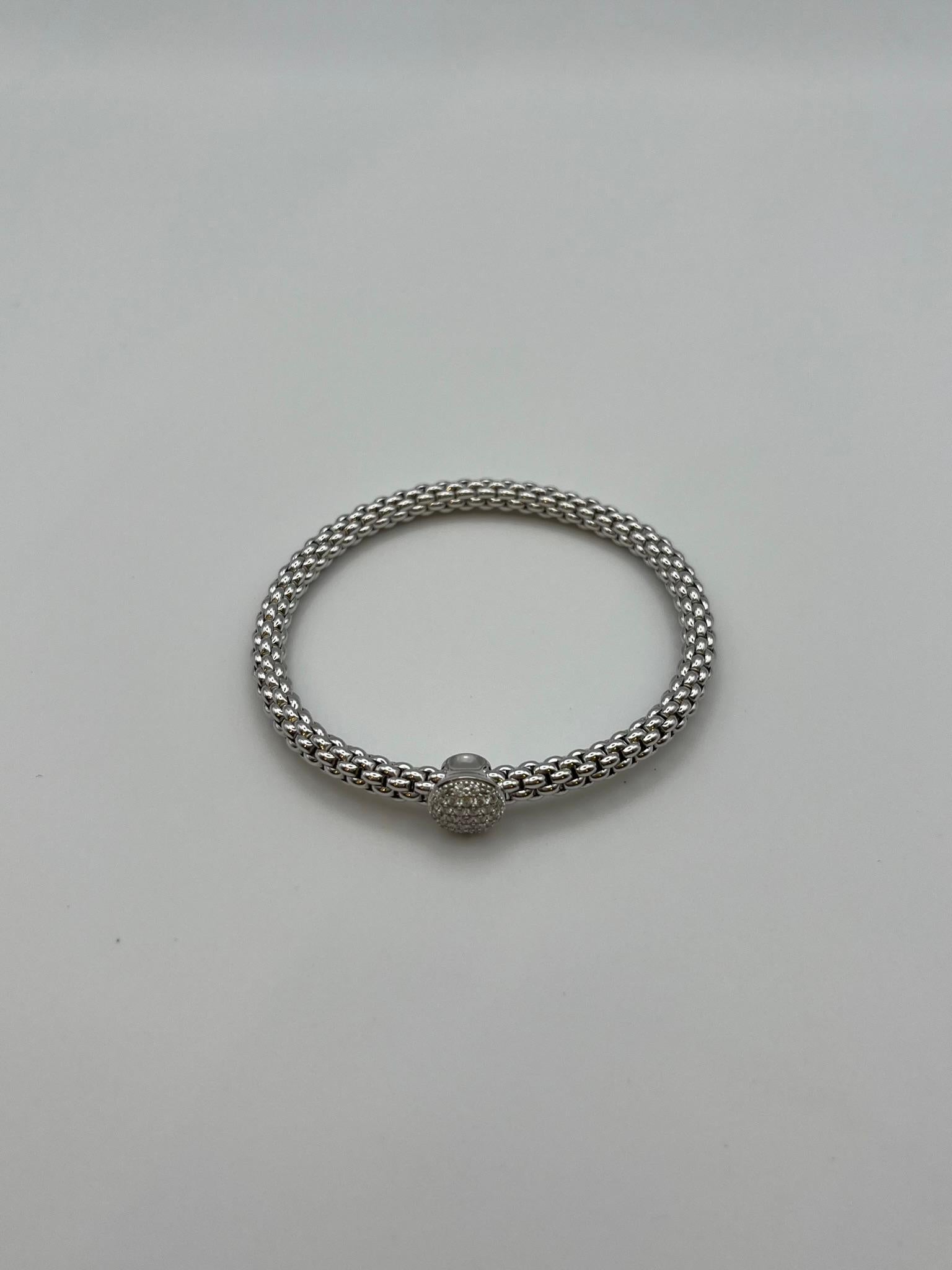 Bracelet Fope de la collection Flex'it en or blanc 18 carats, br. 0.41, orné d'un élégant élément central sphérique pavé de diamants naturels taille brillant d'un poids total de 0.41 carats. Le système élastique interne assure un ajustement