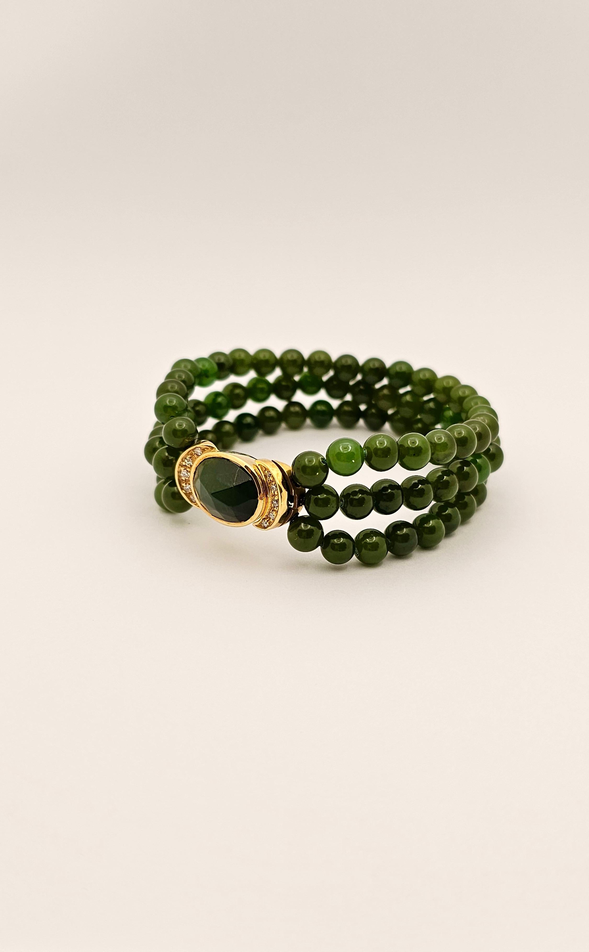 Ein dreisträngiges Armband aus 18-karätigem Gelbgold, natürlicher Jade und Diamanten von der Firma Manfredi.
Dieses Schmuckstück aus dem Jahr 1990 ist neu mit Etikett.
Die Jadeperlen, aus denen das Armband besteht, haben einen Durchmesser von 60