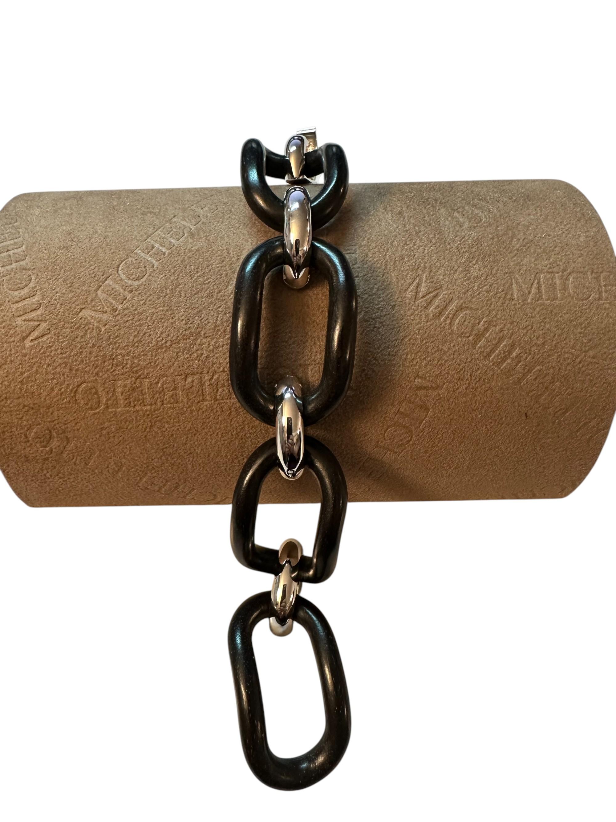 Un cadeau au caractère décidé et distinctif, capable de transformer un accessoire en une déclaration de style. Cette bracciale naît de la rencontre entre la force matérielle de l'ébano naturel, traité avec soin pour souligner les veines profondes et