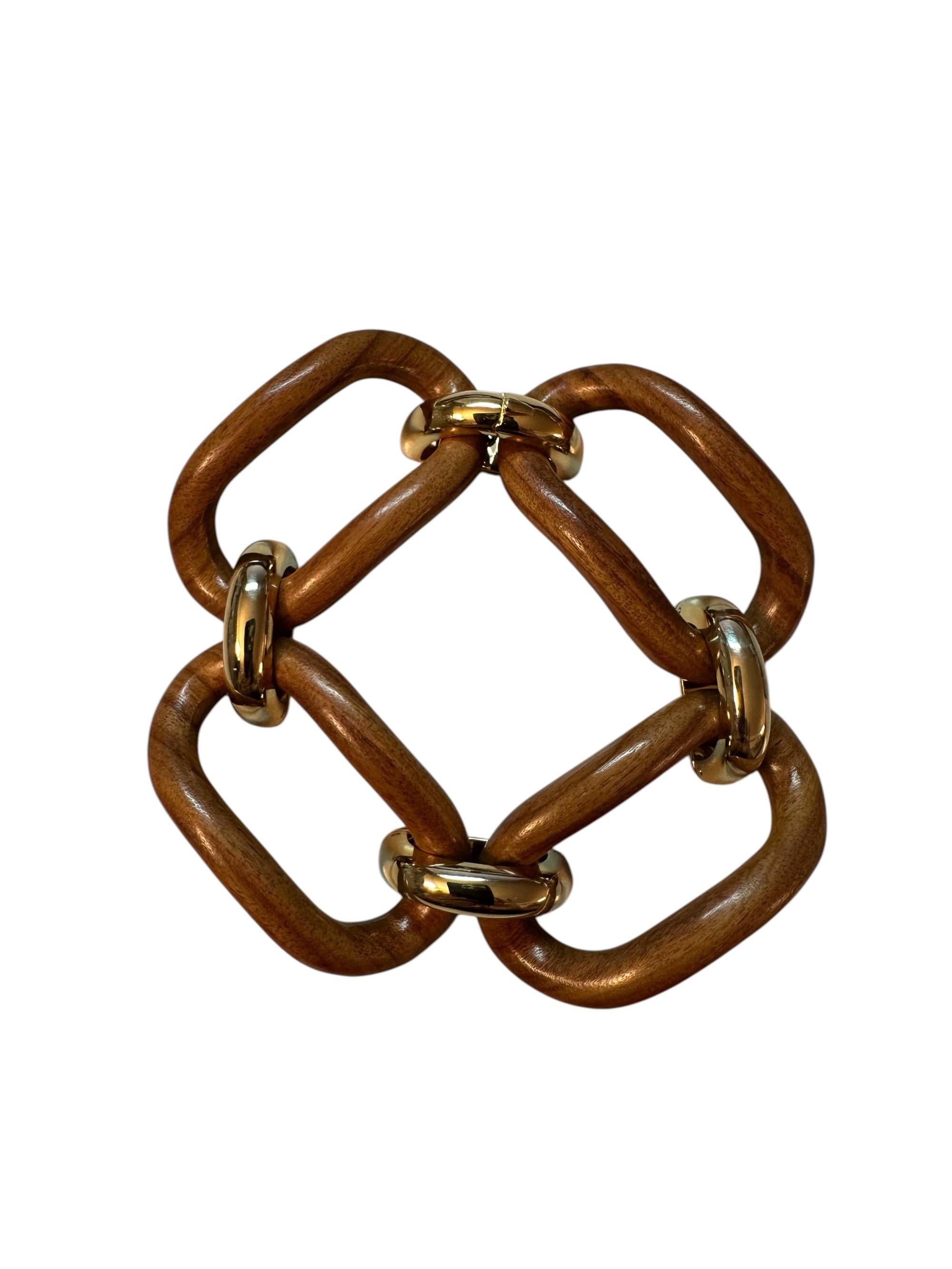 Un gioiello dal carattere deciso e distintivo, capace di trasformare un accessorio in una dichiarazione di stile. Questo bracciale nasce dall'incontro tra la forza materica del palissandro naturale, levigato con cura per esaltarne le venature