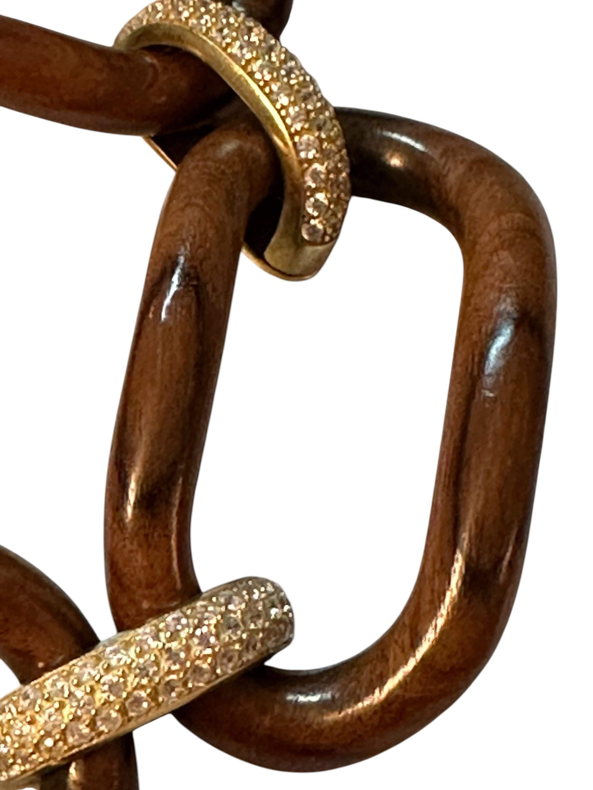 Bracciale in palissandro con maglie in argento placcato oro e zirconi.
Este brazalete representa el encuentro perfecto entre la fuerza de la naturaleza y la elegancia del diseño contemporáneo. Las molduras de palisandro evocan solidez y