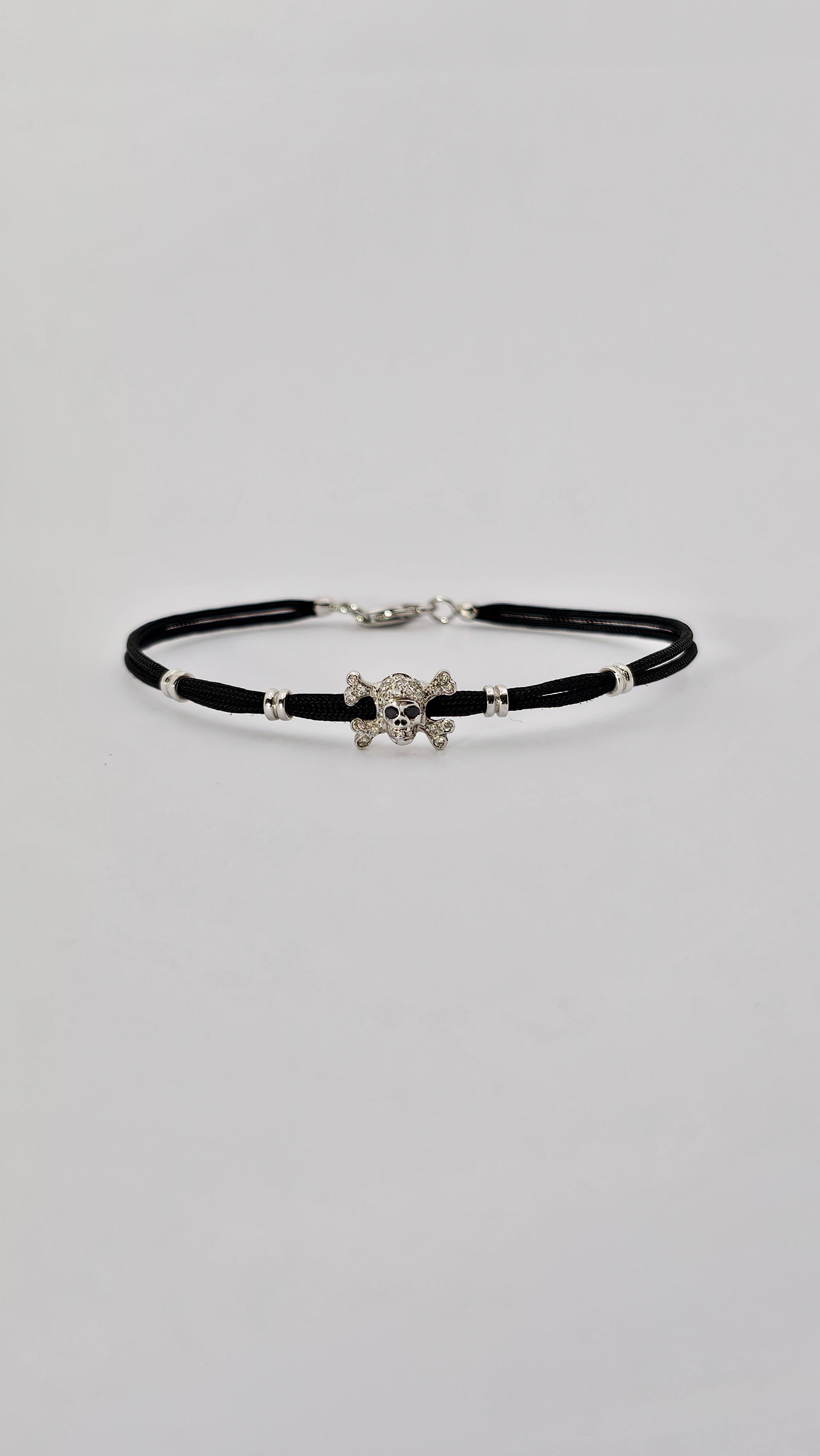 A modern bracelet with a skull inserted made of 18kt white gold and Diamonds.
The skull has white Diamonds all over its surface and set in the eyes are two black Diamonds.
The carat of White Diamonds is 0.20 while the carat of Black Diamonds is