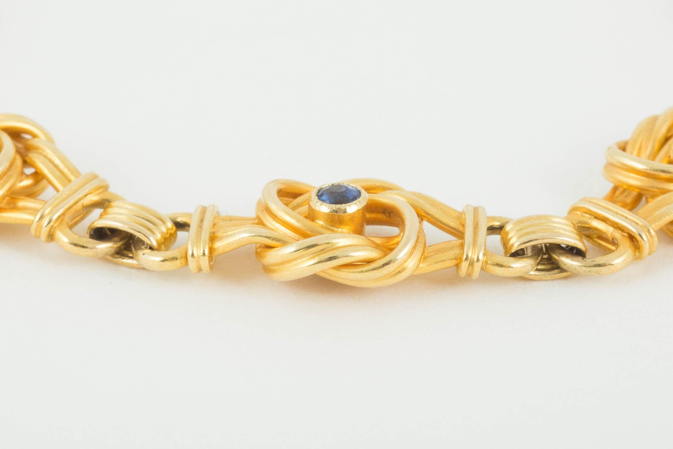A heavy quality, 18carat yellow gold bracelet of eight openwork knot motifs,the central motif is set with a sapphire, the motif either side is set with a natural pearl. The condition and colour perfect.
English circa 1900. Length 17.5 cams, width of