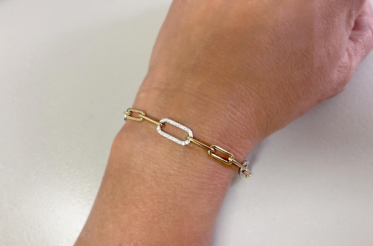 This 18kt gold paperclip bracelet, accented with delicate white gold links adorned with shimmering diamonds, is the embodiment of understated elegance and modern luxury. The bold simplicity of the paperclip design is juxtaposed by the timeless