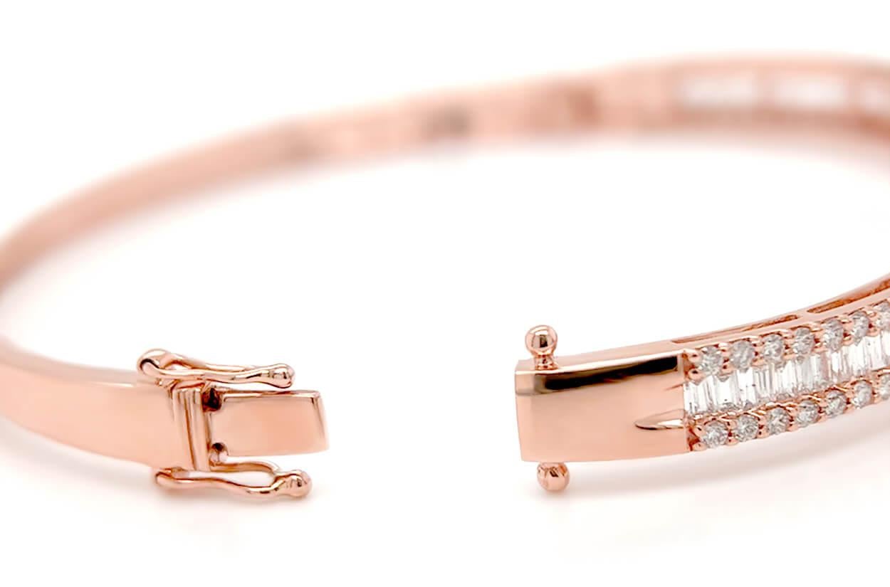 This exquisite bangle is a radiant display of sophistication and luxury. Crafted from lustrous 18kt rose gold, it features a stunning arrangement of baguette-cut diamonds that grace the center, exuding a timeless elegance. The sides of the bangle