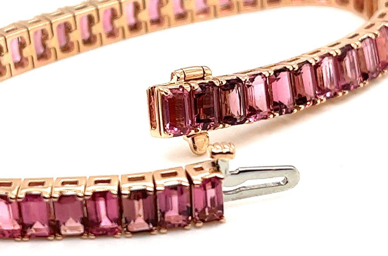 Elevate your wrist with the timeless elegance of this 18kt rose gold tennis bracelet, adorned with a captivating array of emerald-cut tourmaline gemstones. Each gemstone showcases the mesmerizing depths of its rich hues, harmonizing with warm tones