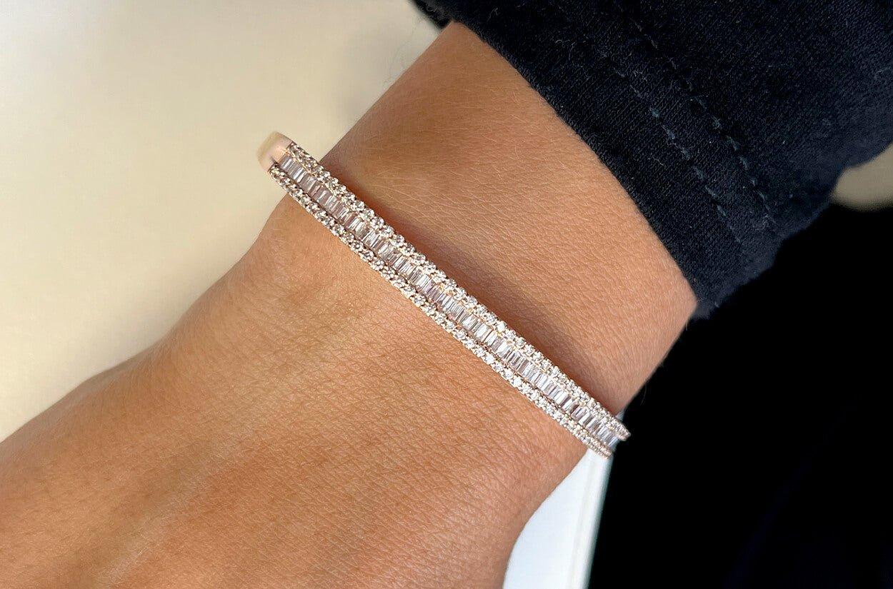 This exquisite bangle is a radiant display of sophistication and luxury. Crafted from lustrous 18kt white gold, it features a stunning arrangement of baguette-cut diamonds that grace the center, exuding a timeless elegance. The sides of the bangle